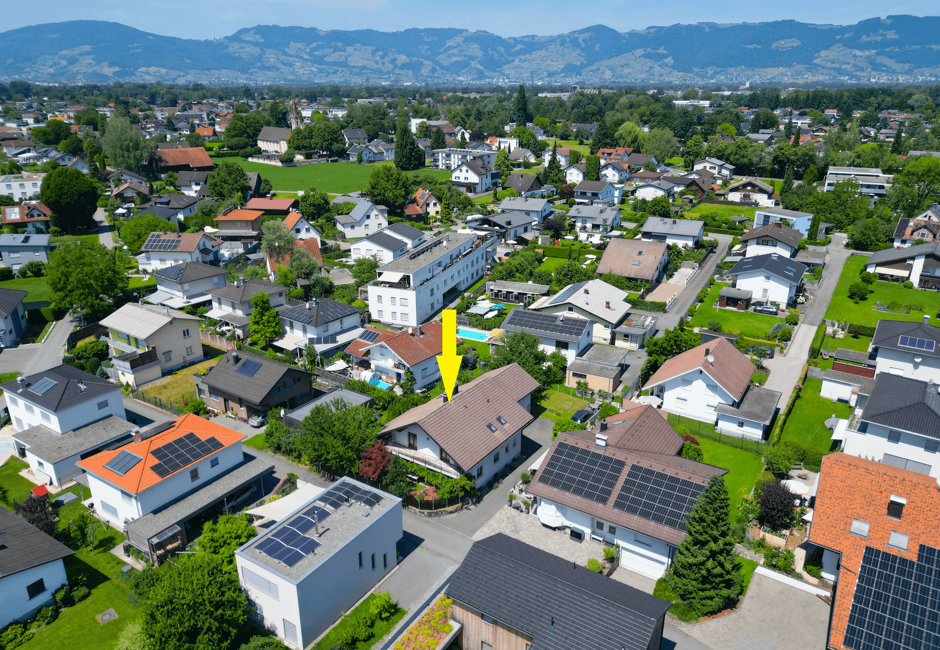 Weitläufige Luftaufnahme der Wohngegend mit dem markierten Haus und umliegender Natur.