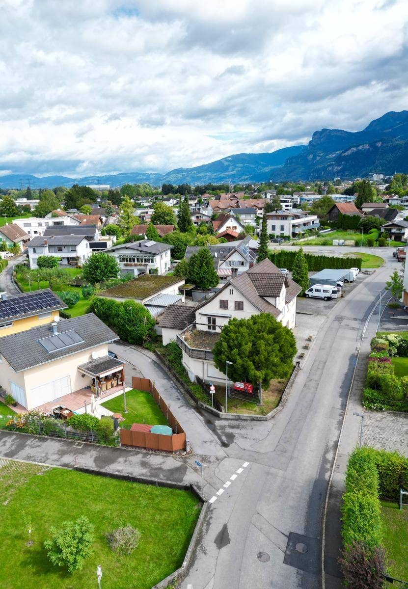 Weitläufige Luftaufnahme der Wohngegend mit Bergen im Hintergrund und vielen Einfamilienhäusern.