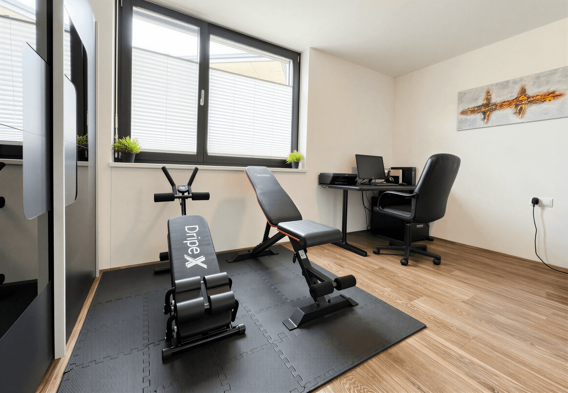 Vielseitiger Raum, eingerichtet als Fitnessbereich und Home-Office mit Schreibtisch.