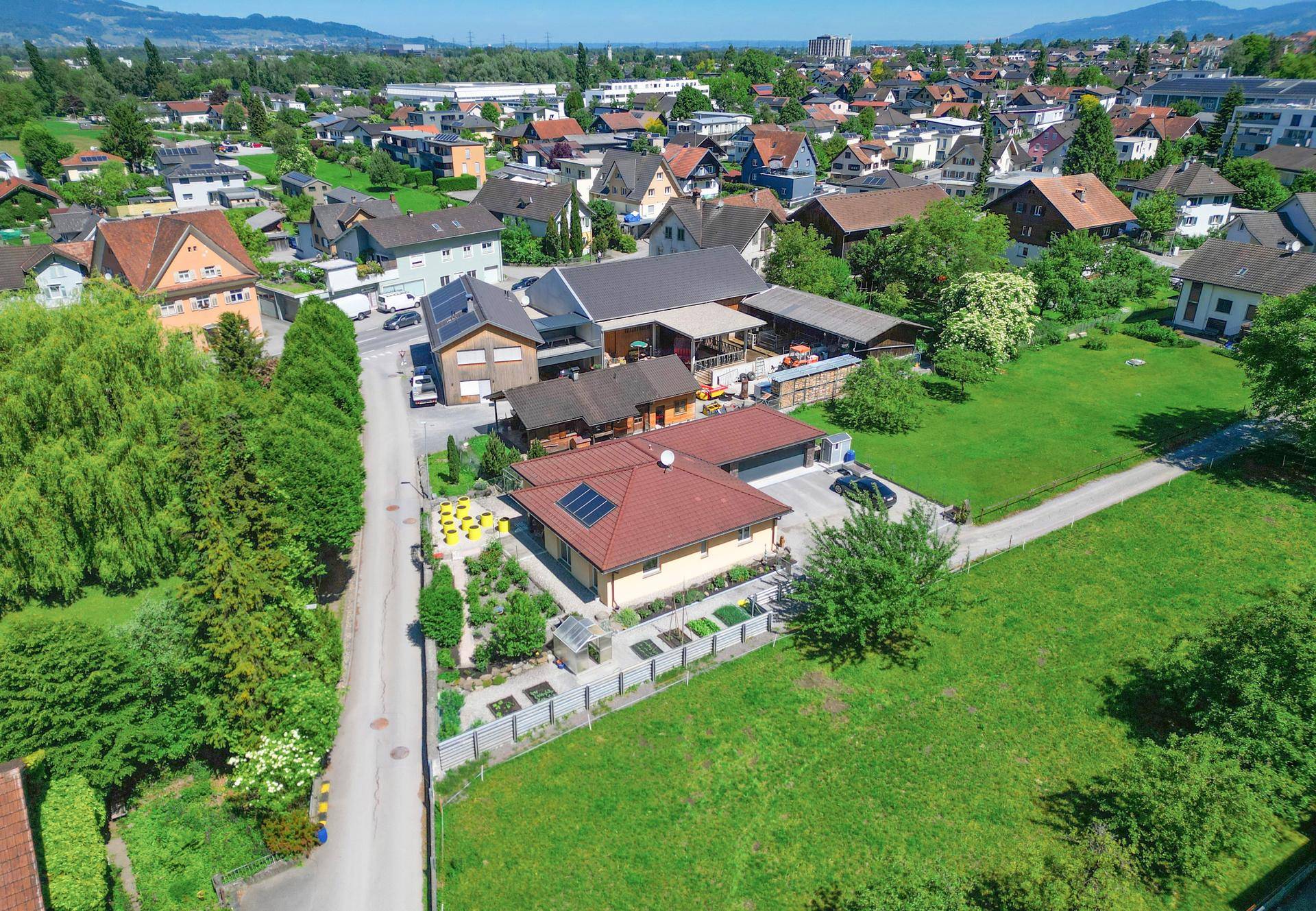 Weitläufige Luftaufnahme des Anwesens und der umliegenden Wohngegend mit viel Grün.