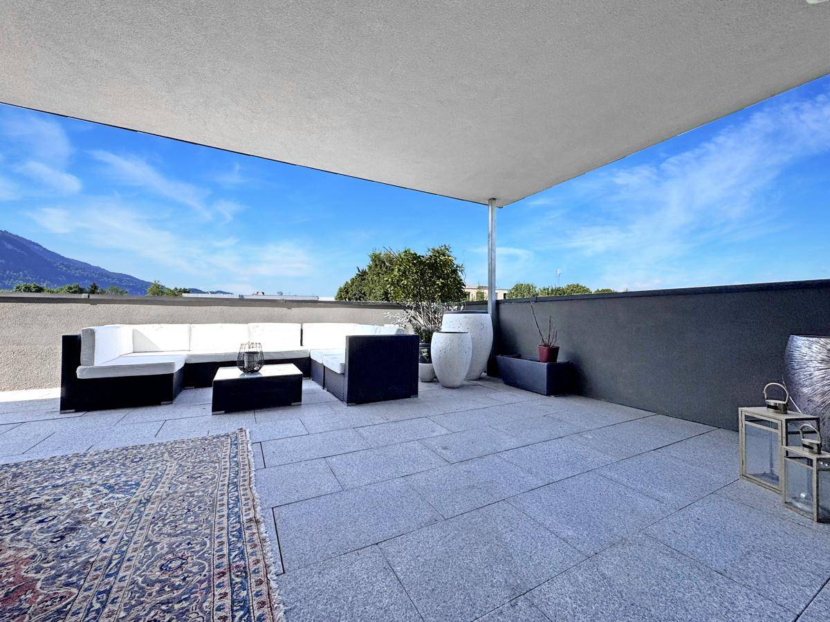 Geräumige Dachterrasse mit Lounge-Möbeln und weitem Blick auf die Berge.