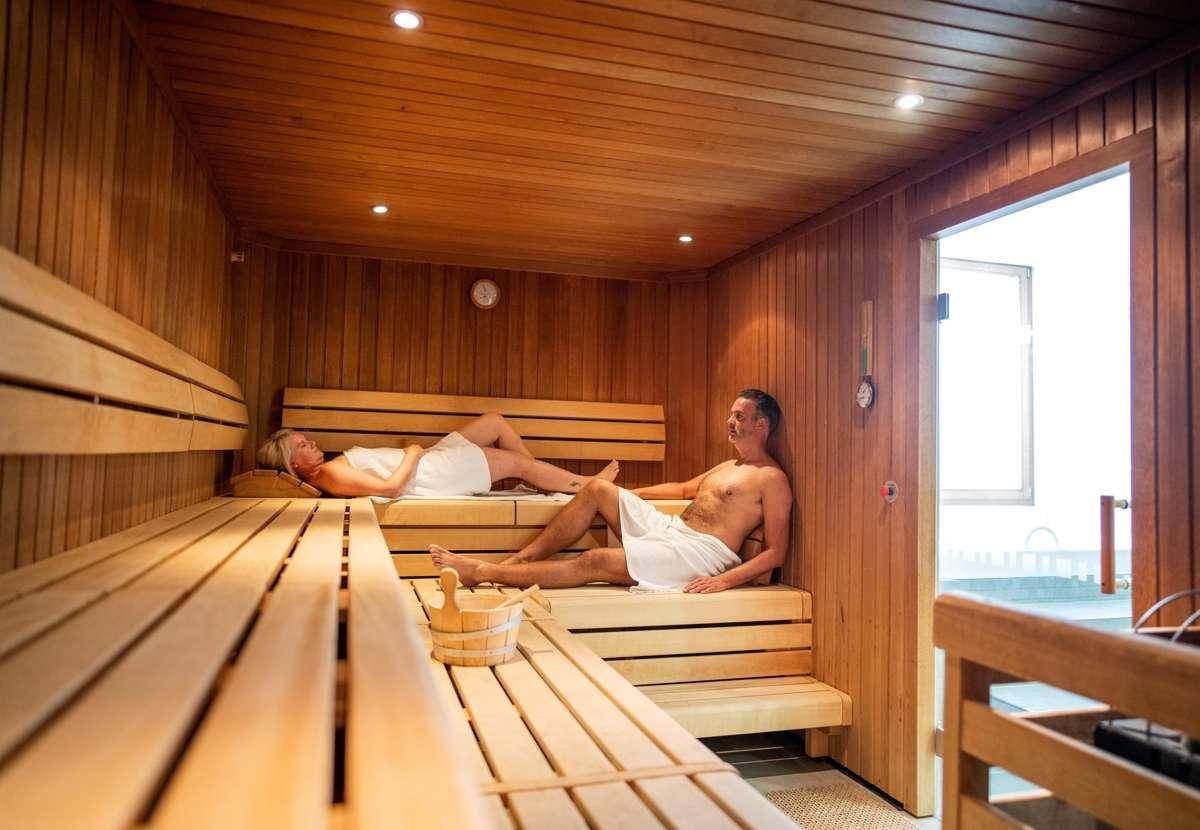 Geräumige Sauna mit Holzverkleidung und bequemen Liegebänken, ideal zur Entspannung.