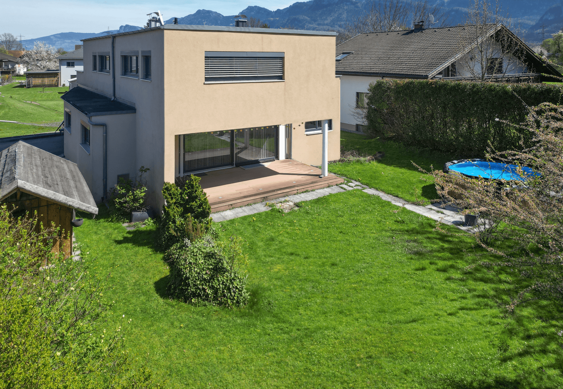 Luftaufnahme des modernen Hauses mit großem Garten, Terrasse und Aufstellpool.