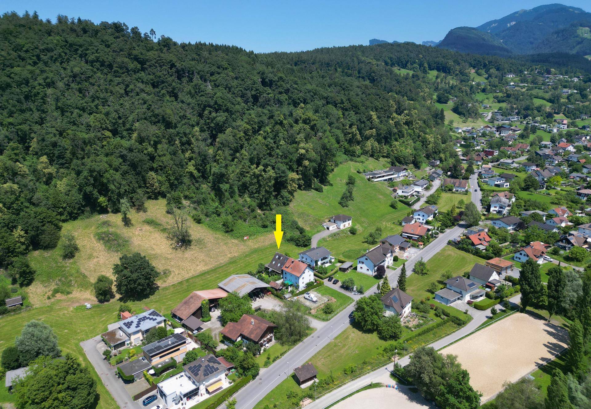 Weitläufige Luftaufnahme eines Wohngebiets mit vielen Häusern und grüner Landschaft.
