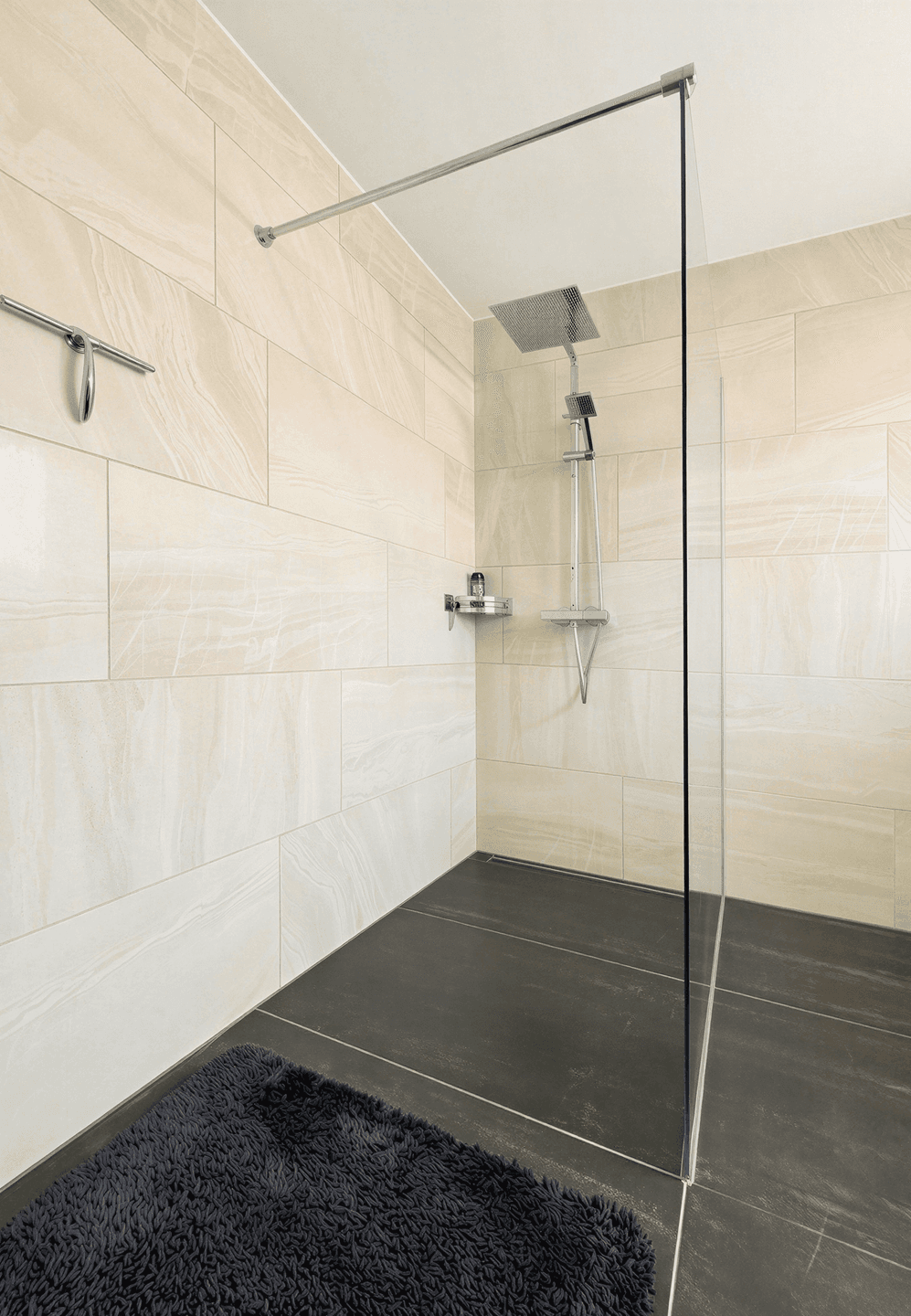 Geräumige begehbare Dusche mit Regenduschkopf und modernen Fliesen.