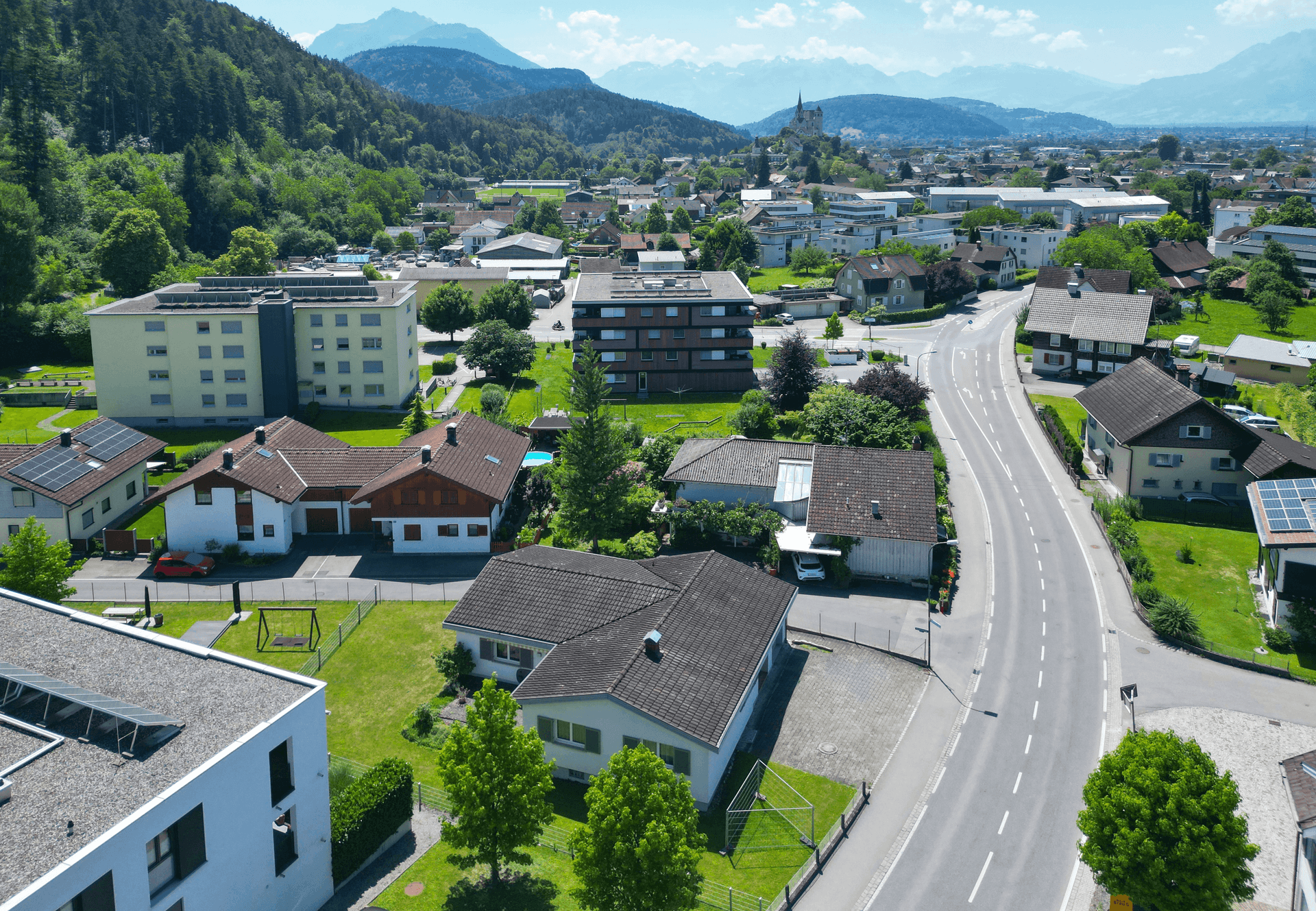 Panoramische Luftaufnahme der Wohnsiedlung mit Straßen, Häusern und der umliegenden Natur.