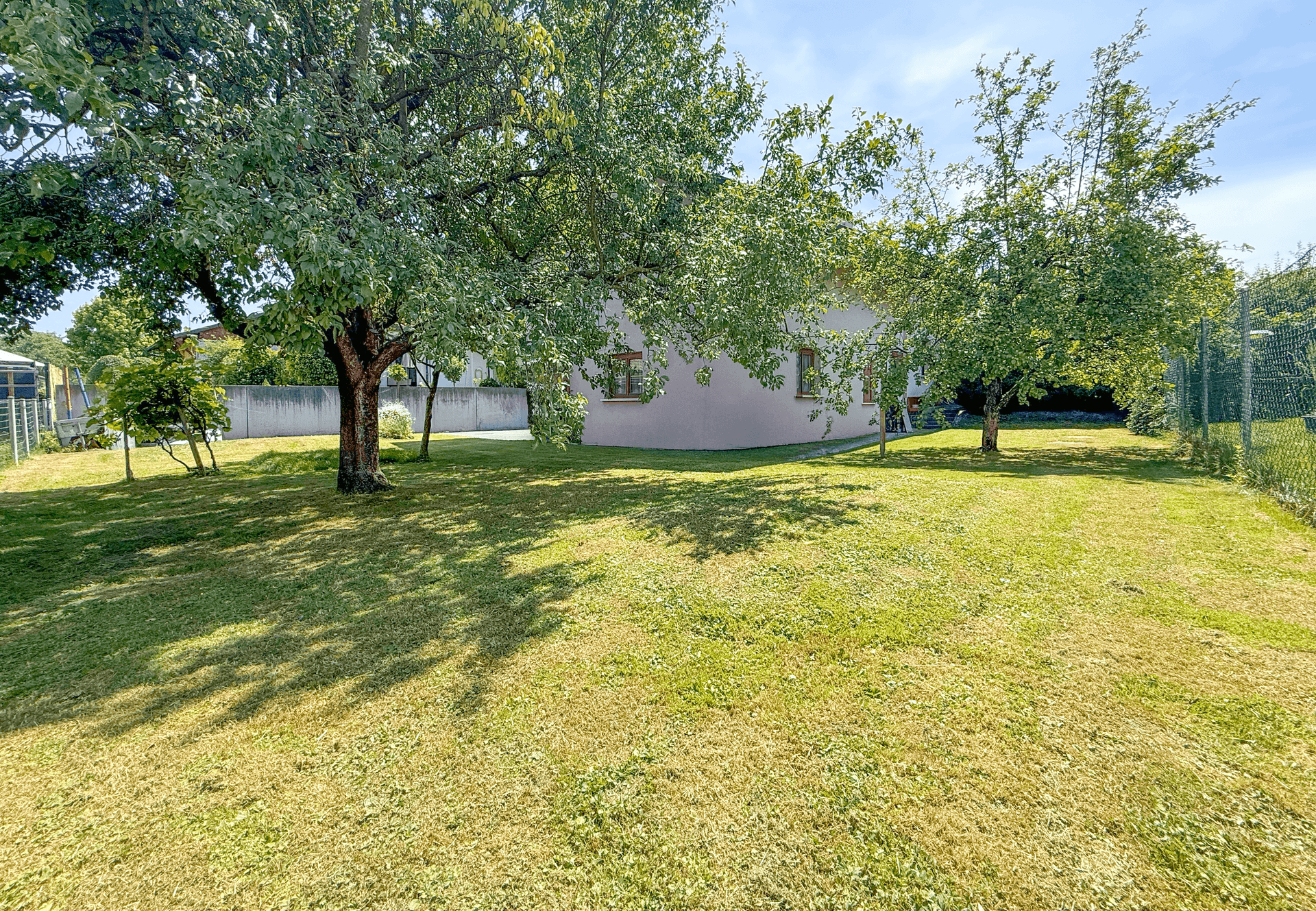 Großer, sonniger Garten mit Obstbäumen und viel Platz zum Spielen und Entspannen.