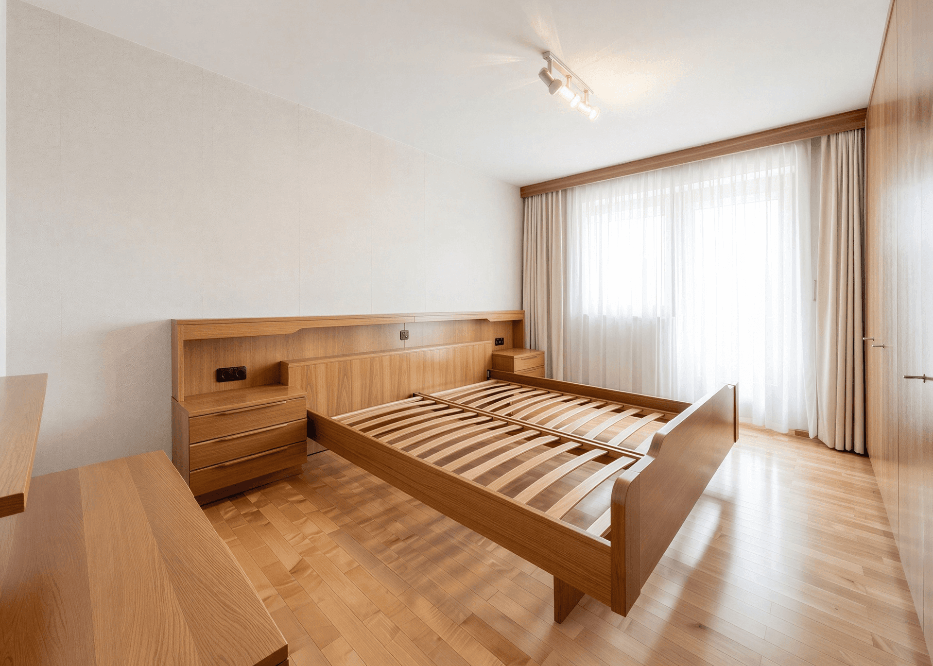 Schlafzimmer mit Holzbett, Nachttischen und Einbauschränken in hellem Holz.