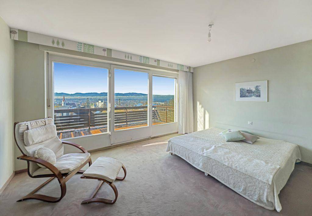 Schlafzimmer mit großem Fenster, das einen weiten Blick bietet, und Teppichboden.