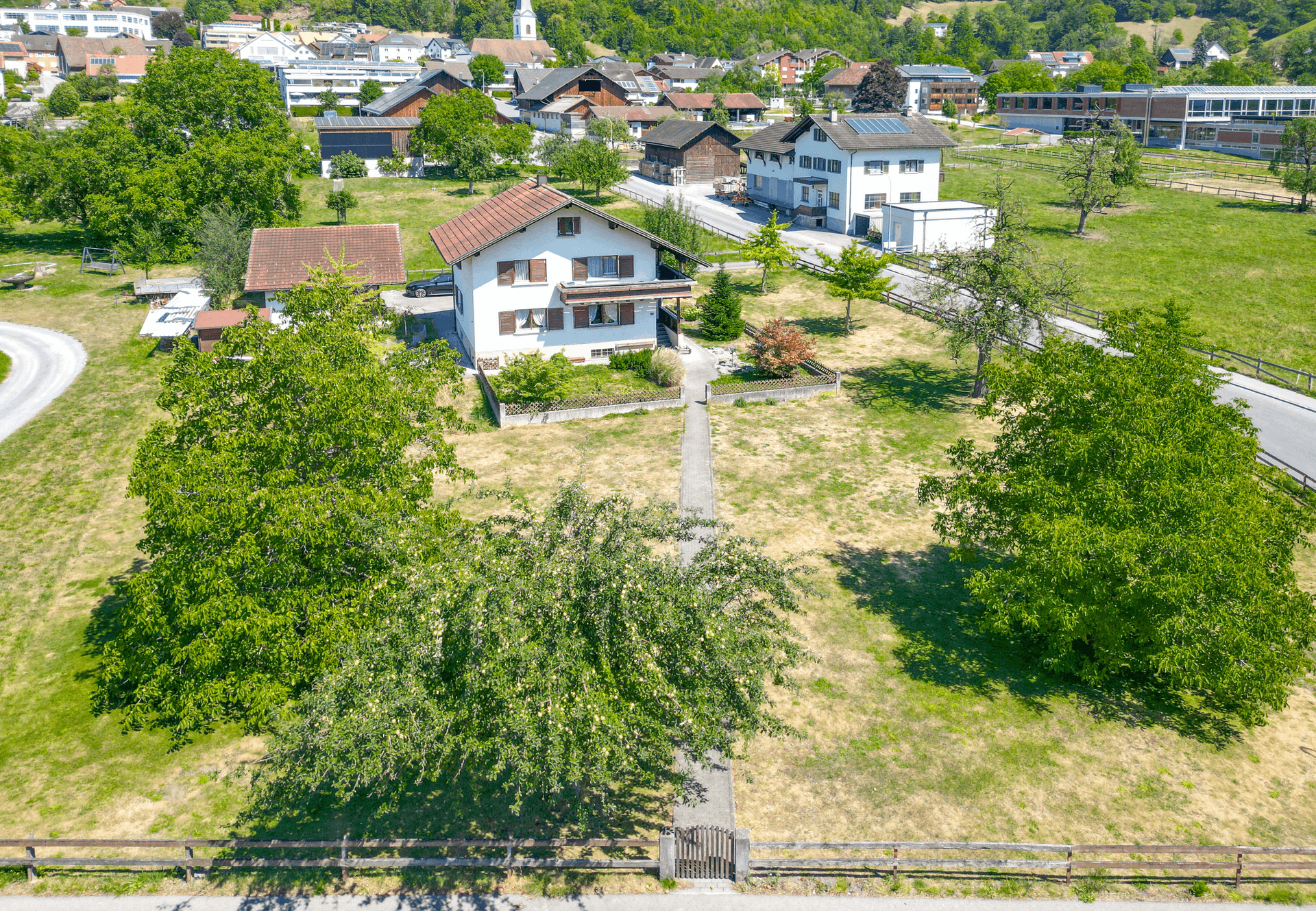 Weitläufige Ansicht des Hauses und des Grundstücks, eingebettet in eine ländliche Umgebung mit Blick auf das Dorf.