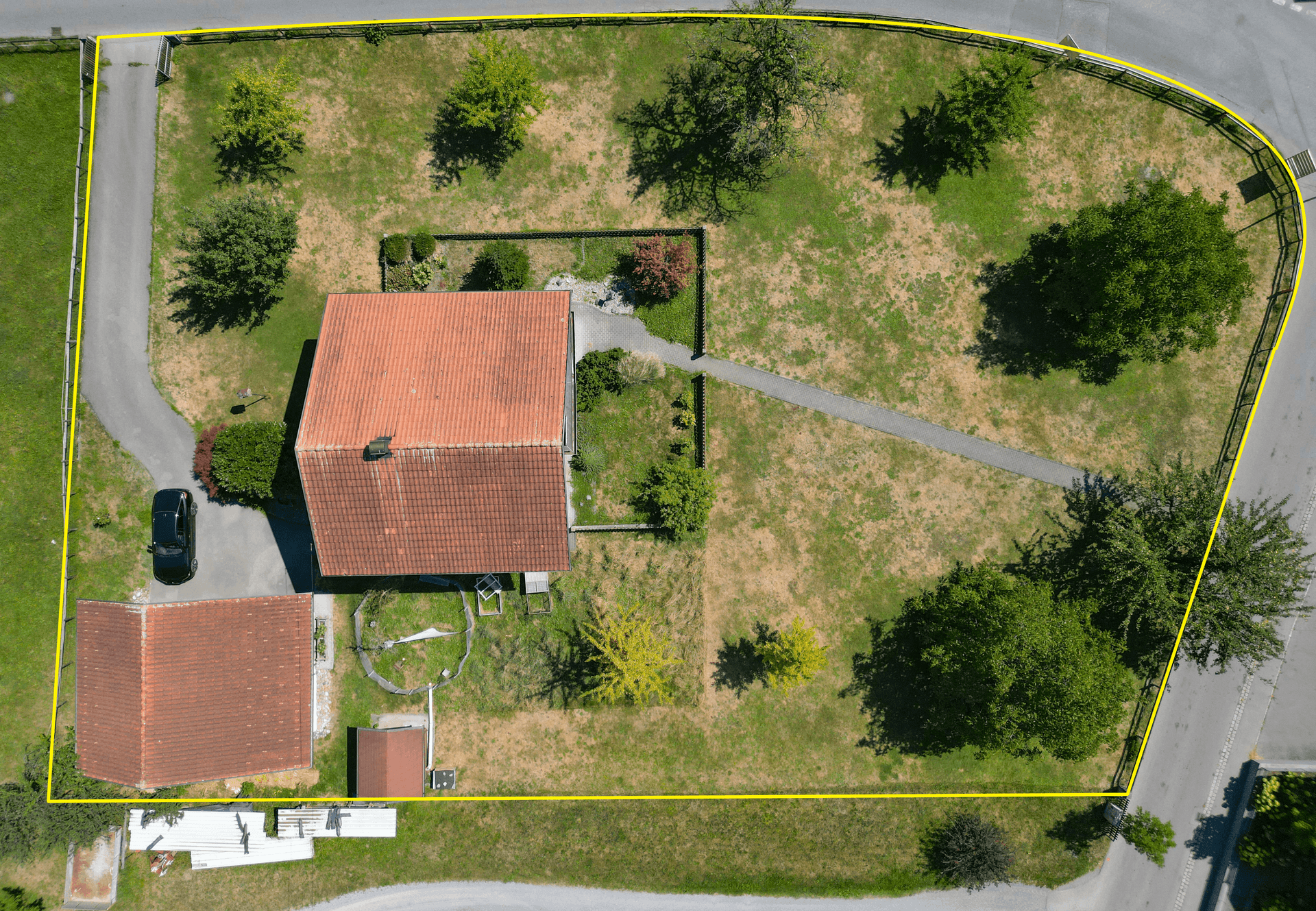 Detaillierte Draufsicht des Grundstücks mit Einfamilienhaus, Garage und klar abgegrenzten Grenzen.