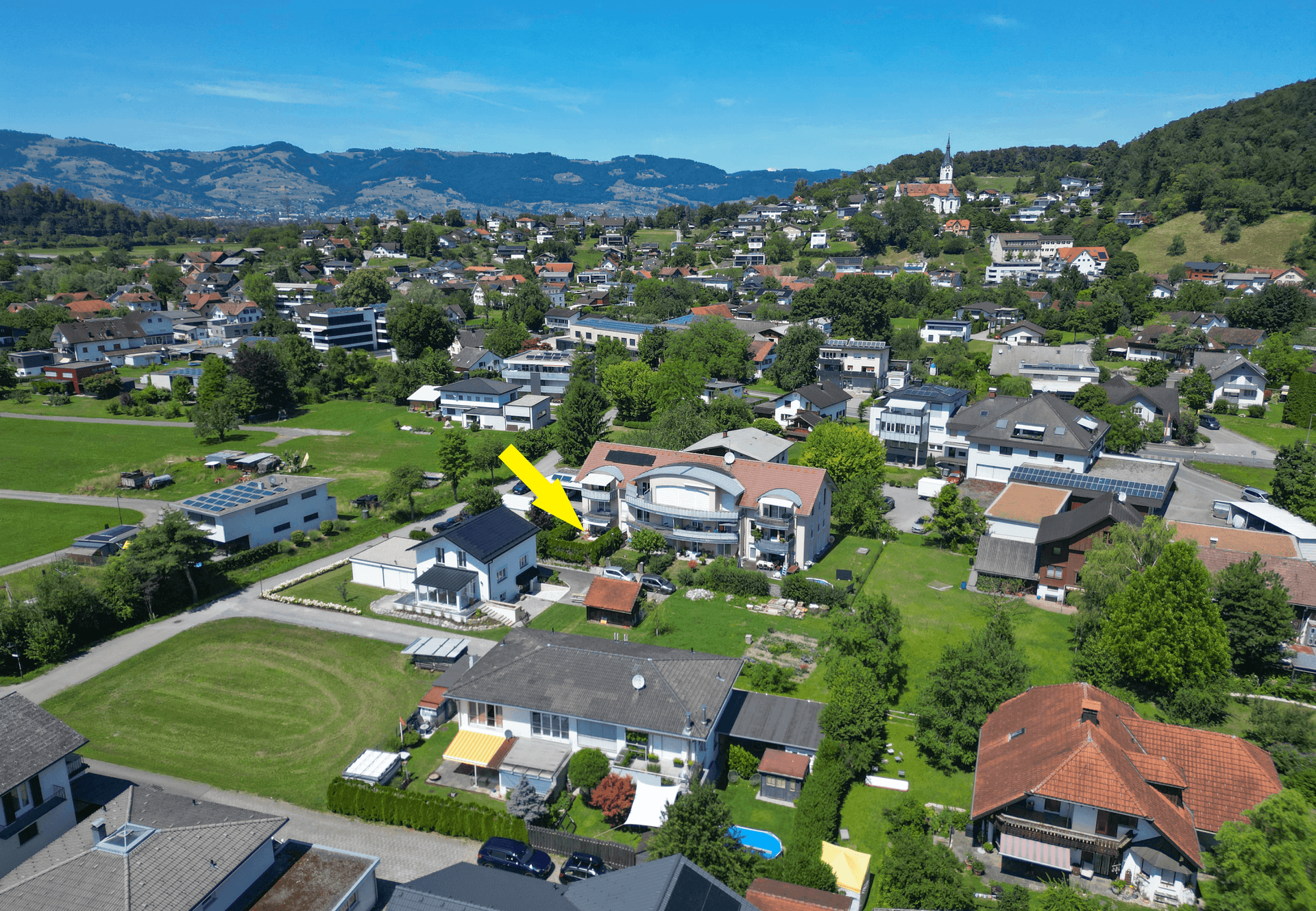 Übersicht aus der Vogelperspektive der Wohngegend mit markiertem Gebäude und grüner Landschaft.