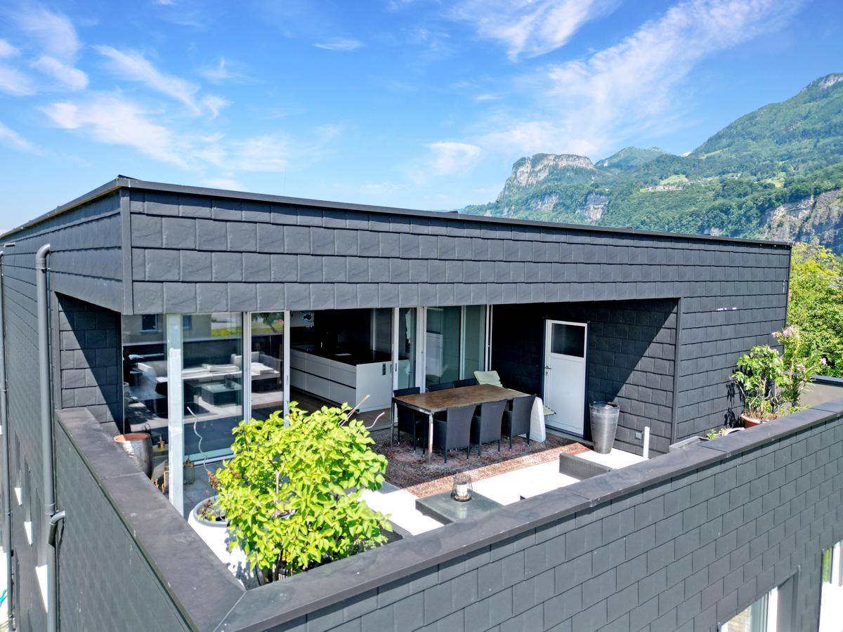 Obere Terrasse mit Essbereich und Blick auf die umliegende Landschaft und Berge.