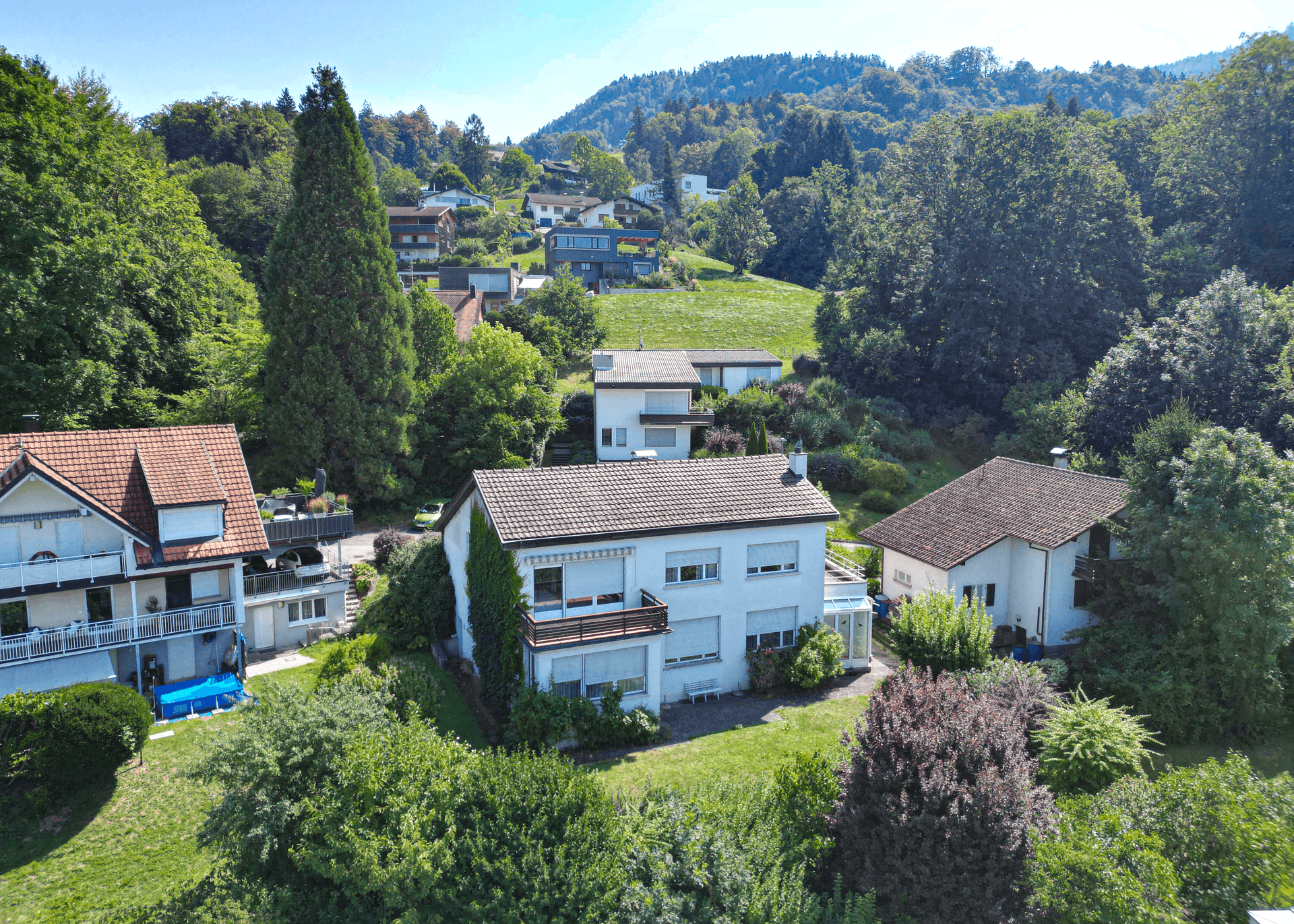 Weitläufige Luftaufnahme eines Wohnhauses mit großem Garten und umliegender Natur.
