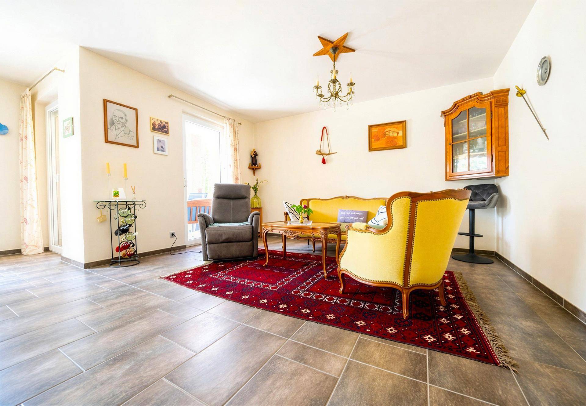 Gemütliches Wohnzimmer mit traditionellen Möbeln, Fliesenboden und Zugang zum Außenbereich.