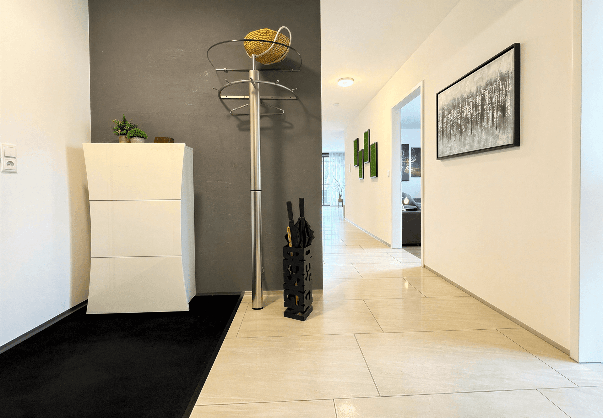 Heller Flur mit Garderobe, Schuhschrank und Fliesenboden.