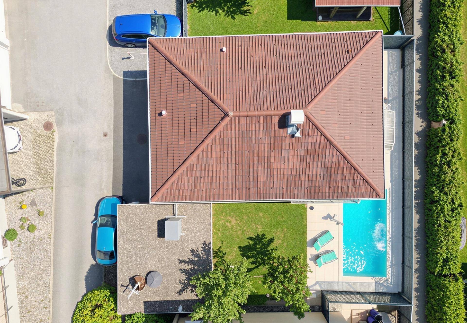 Vogelperspektive des Hauses mit Pool, Garten und Parkplätzen.