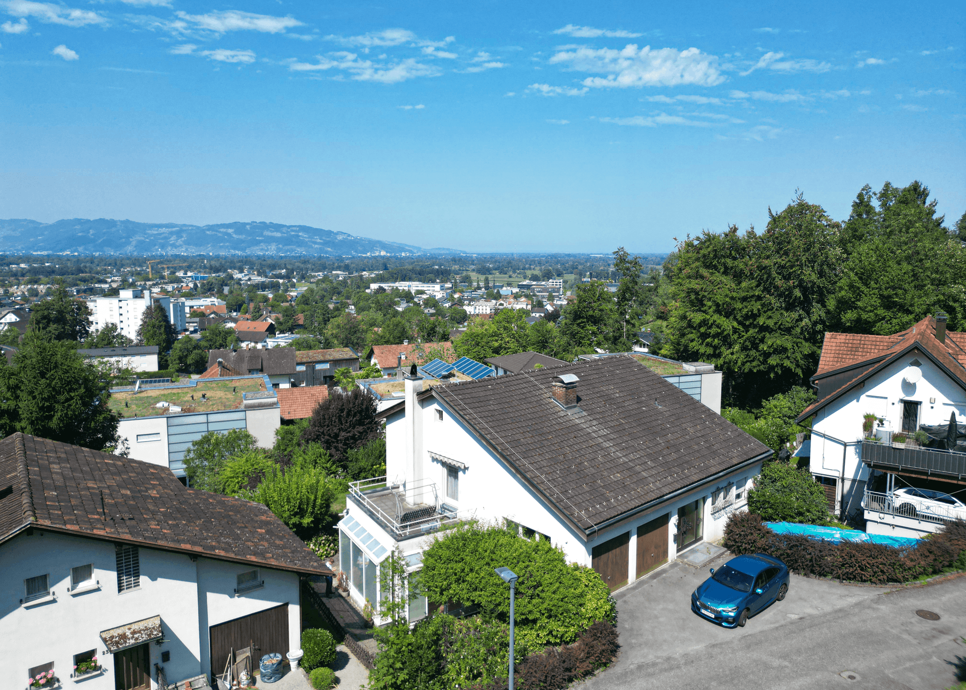 Panoramablick aus der Vogelperspektive auf eine Wohngegend mit Häusern und viel Grün.