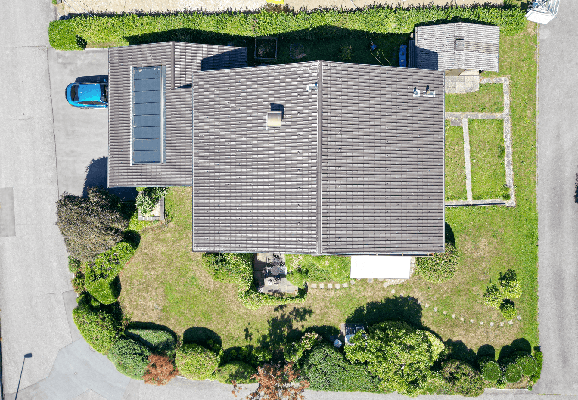Senkrechte Luftaufnahme des Hauses mit Dach, Garten und angrenzenden Grundstücken.