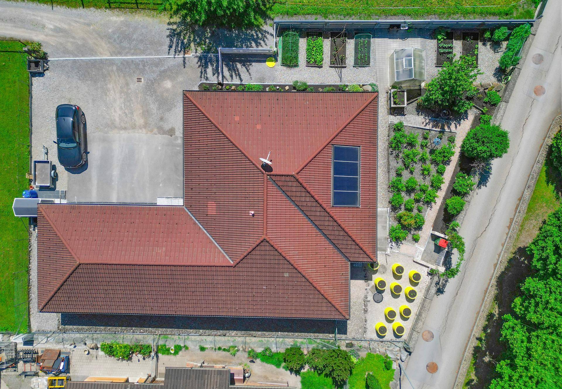 Draufsicht aus der Luft auf das Haus, den Garten und die Zufahrt mit Solaranlage.