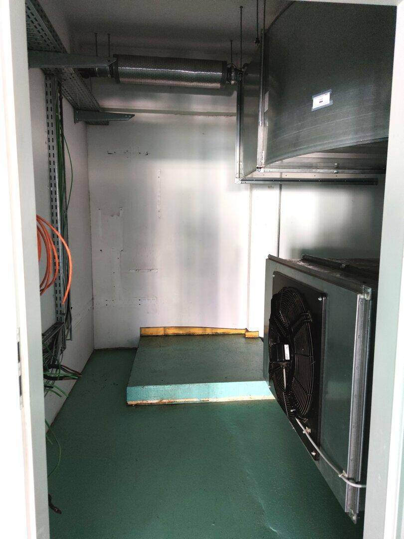 Kleiner Technikraum mit Lüftungsanlage und sichtbaren Installationen für die Gebäudetechnik.