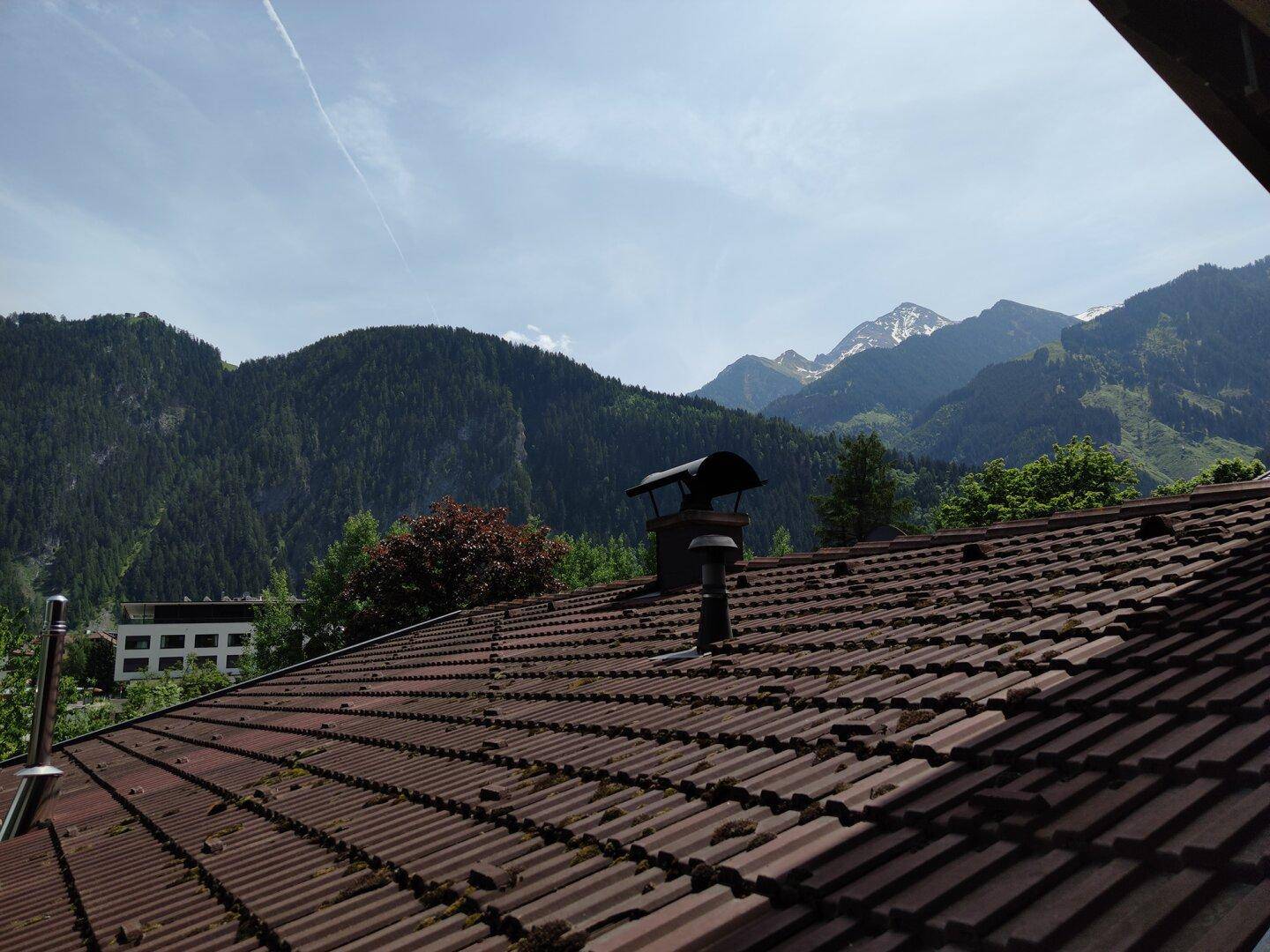Weitläufiger Blick über die Dächer der Häuser auf die majestätischen Berge.