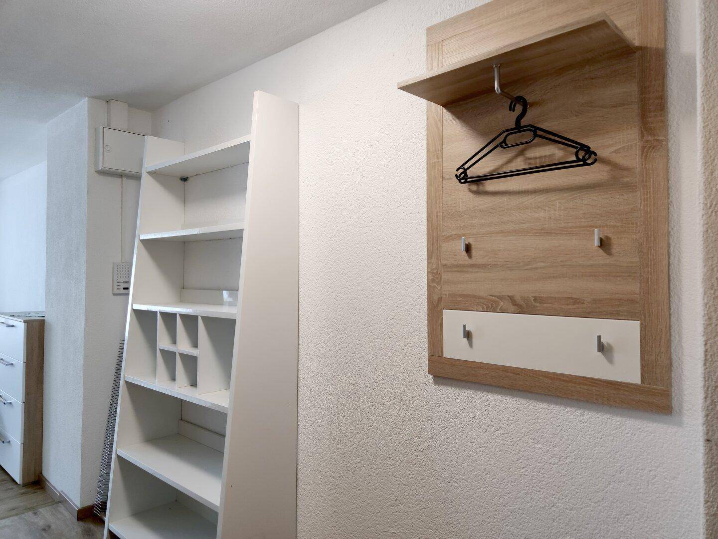 Eingangsbereich mit Garderobe und praktischen Regalen für zusätzlichen Stauraum.