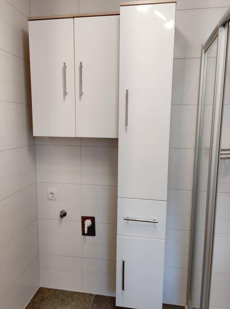 Praktischer Raum mit Anschlüssen für Waschmaschine und Trockner sowie Stauraum.