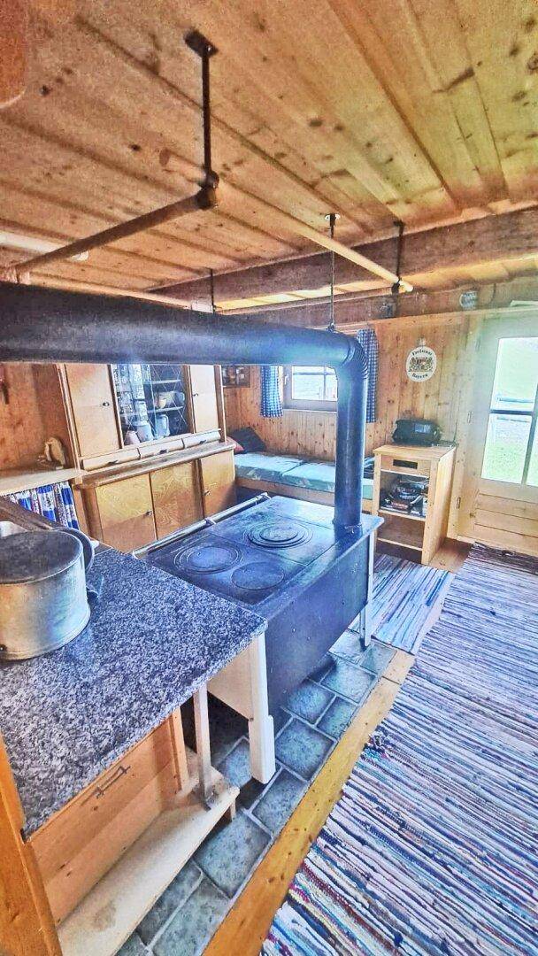 Geräumige Holzküche mit traditionellem Holzofen, Arbeitsflächen und rustikalem Charme.