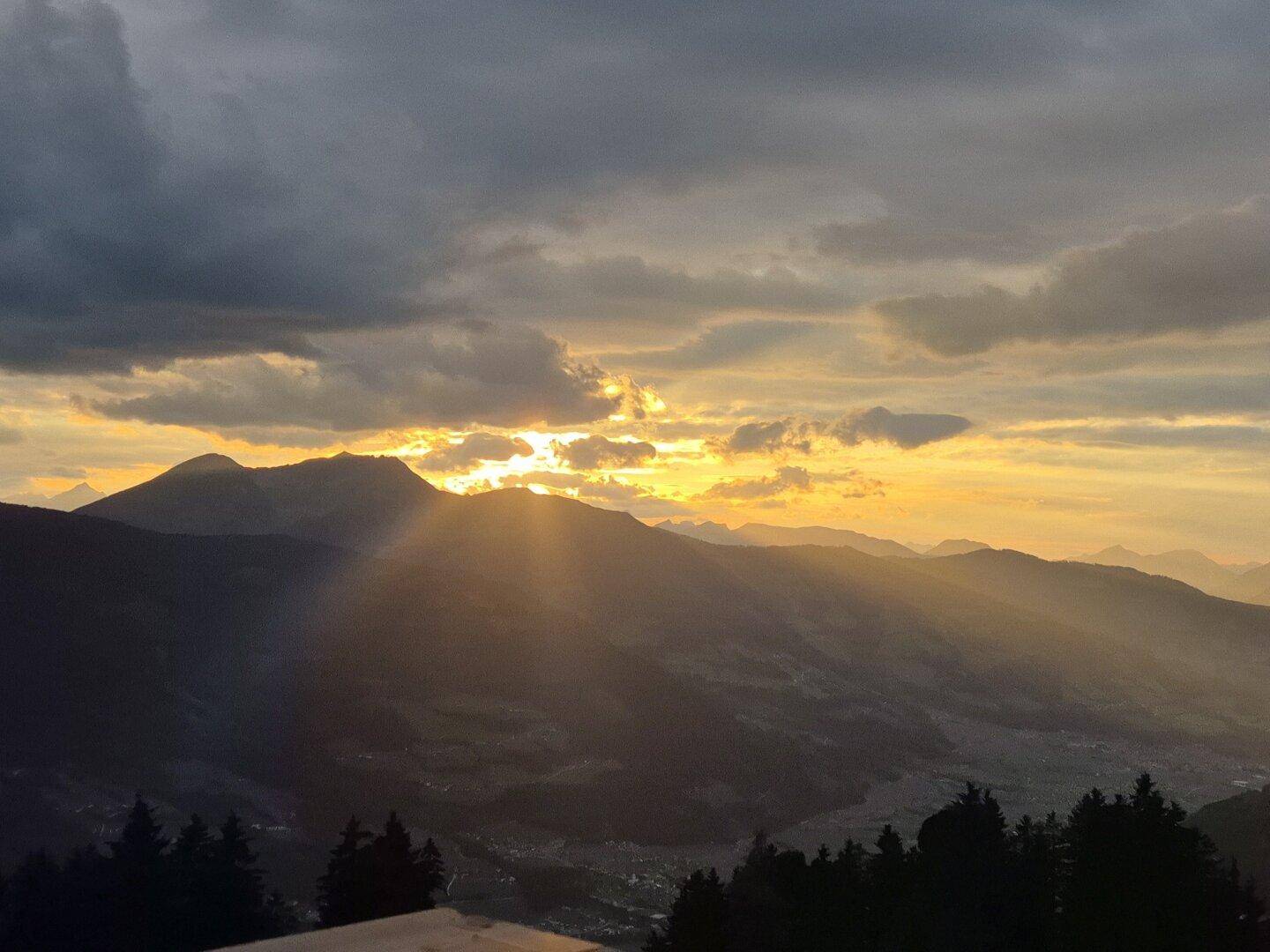 Spektakulärer Sonnenuntergang über den majestätischen Bergen, der den Himmel in warmen Farben färbt.