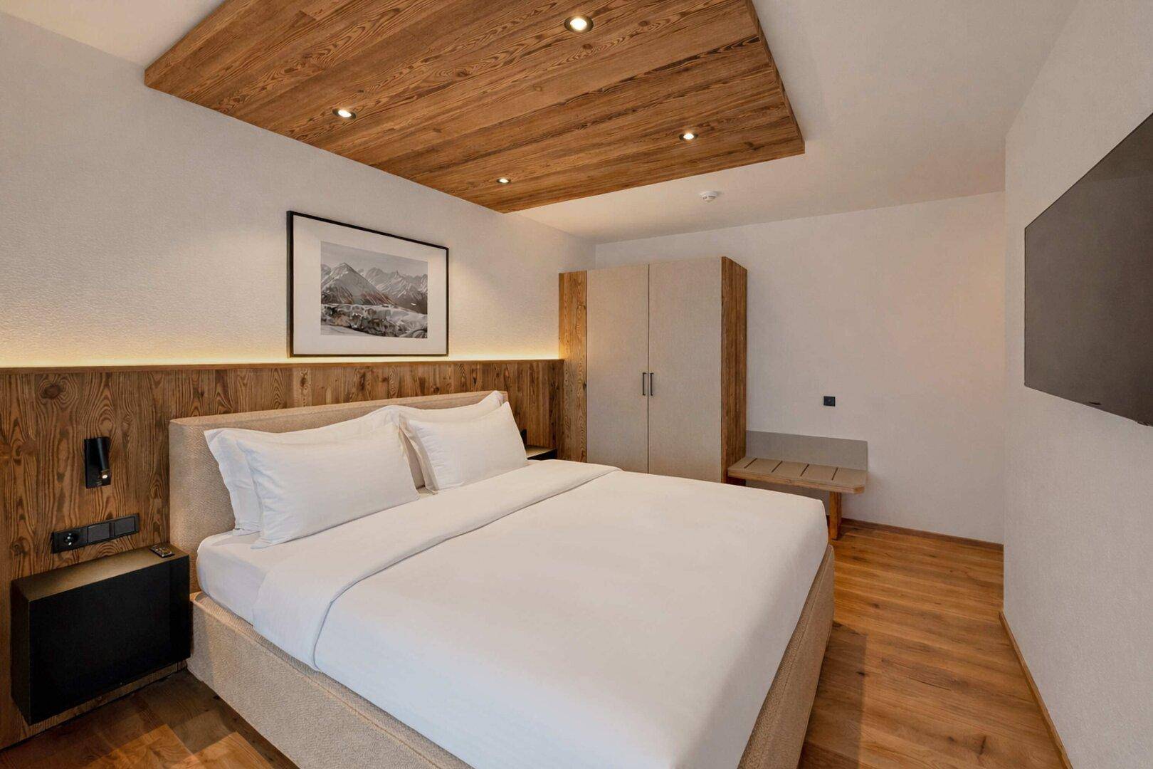 Gemütliches Schlafzimmer mit Holzboden, Holzakzenten und Einbauschrank.