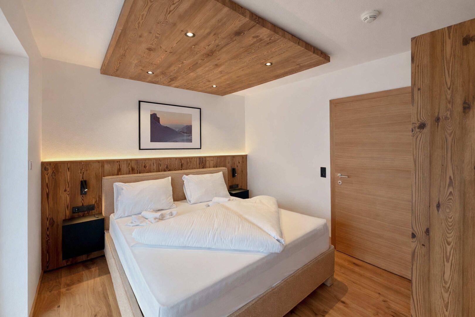 Modernes Schlafzimmer mit Holzboden, Holzakzenten und schlichtem Design.