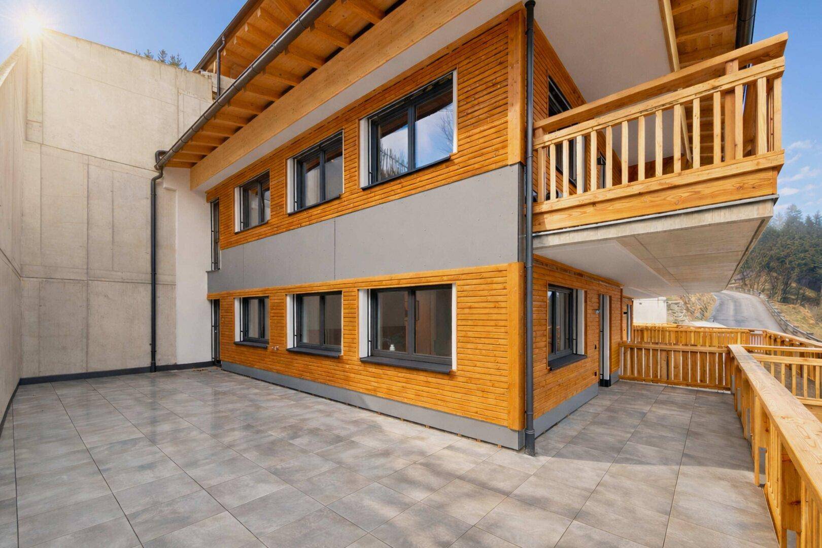Moderne Architektur mit Holzfassade und großzügiger Terrasse im alpinen Stil.