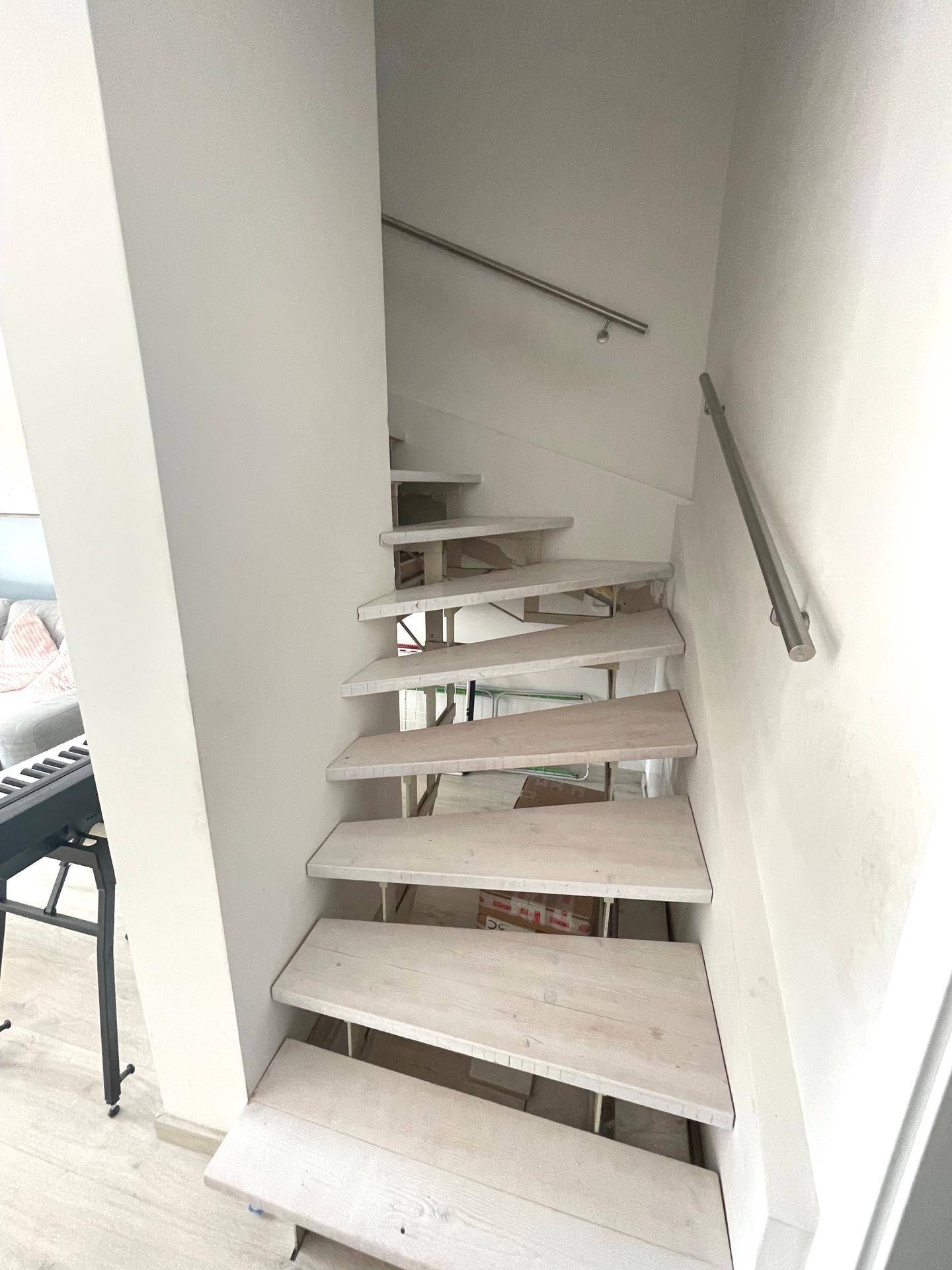 Moderne Holztreppe mit schwebenden Stufen und Edelstahlgeländer.