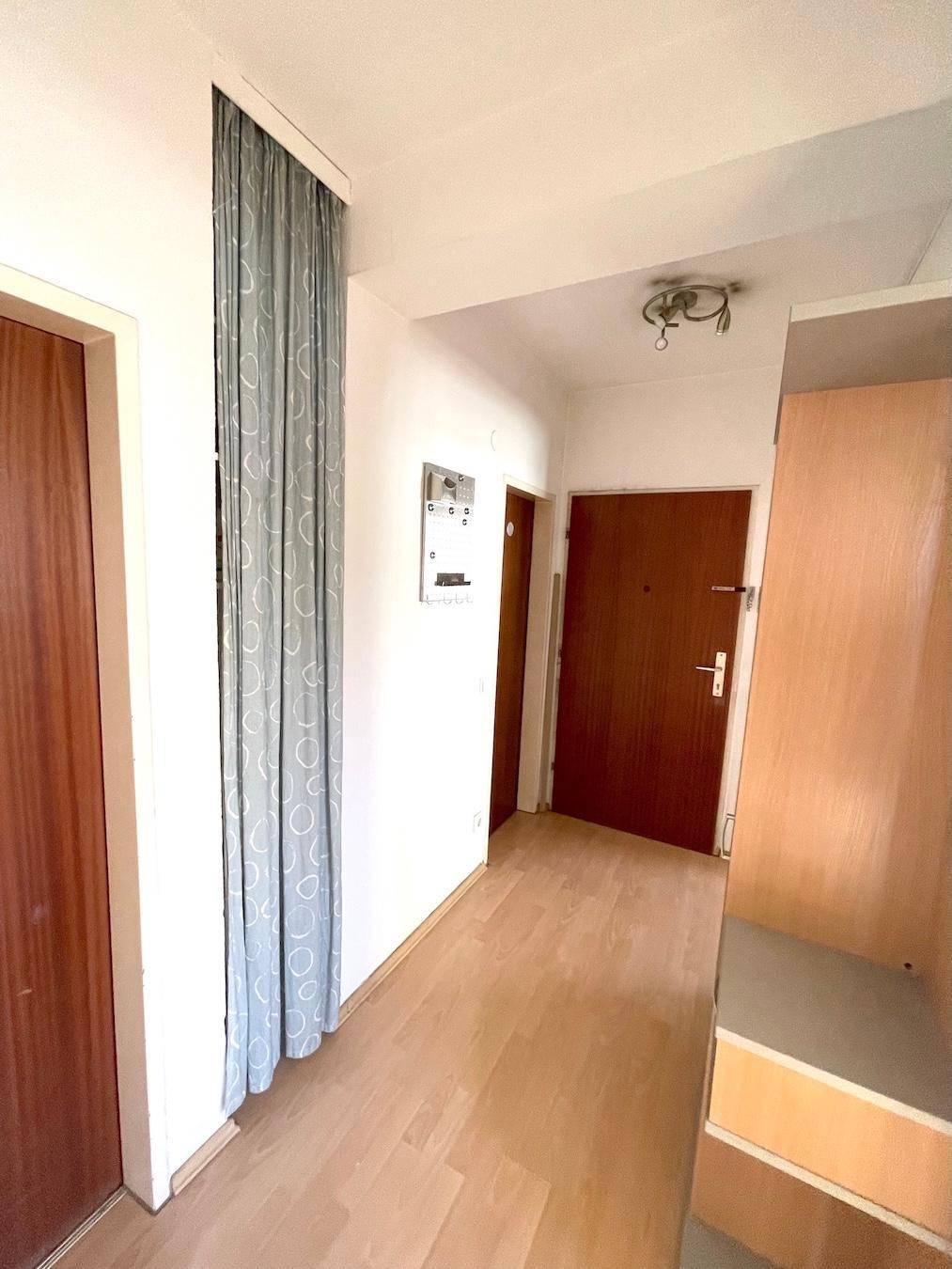 Eingangsbereich mit Parkettboden, Garderobe und Zugang zu den weiteren Räumen.