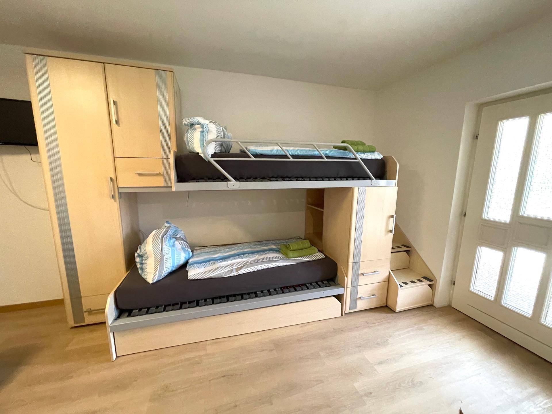 Ein Schlafbereich mit modernem Etagenbett und integriertem Stauraum.