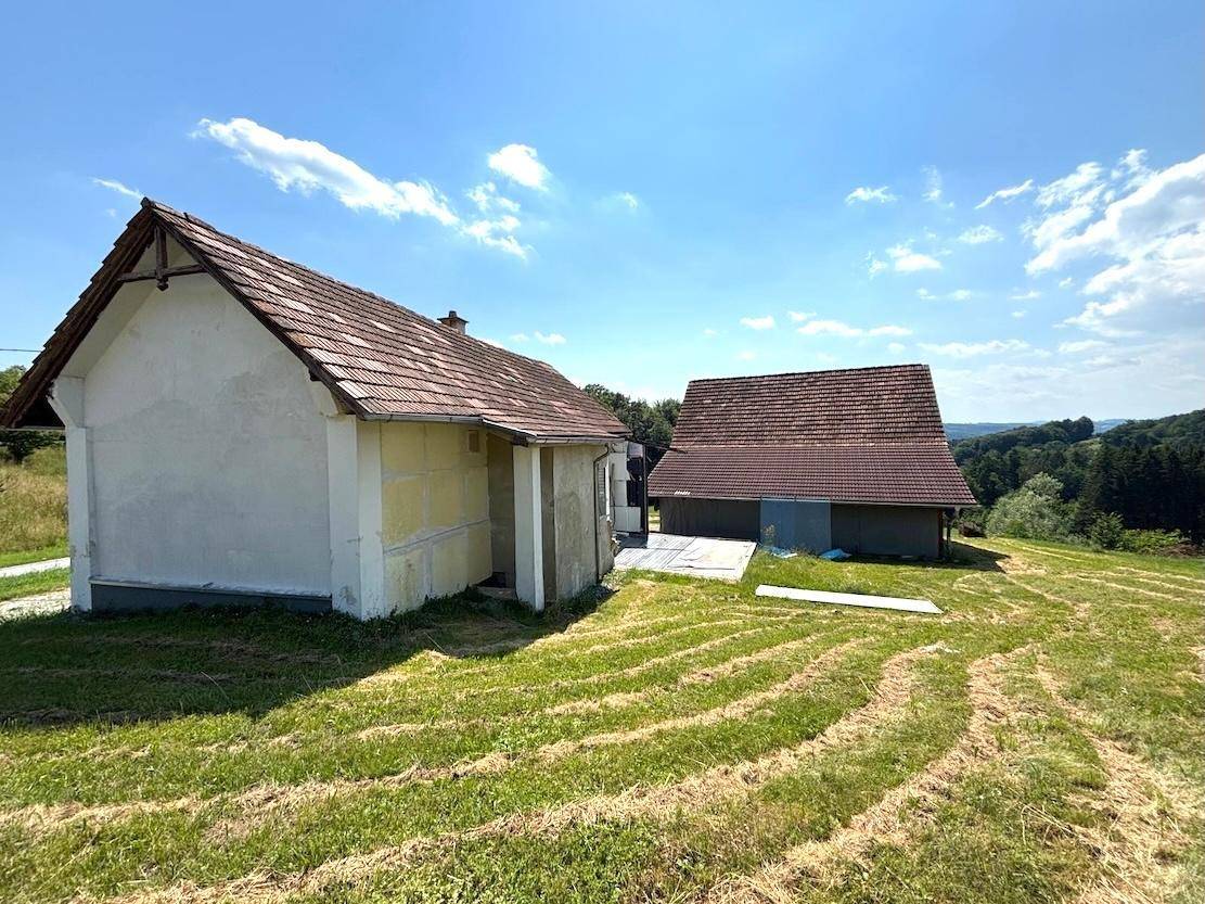 Überblick über das Anwesen mit dem kleinen Haus und einem weiteren Gebäude in der Ferne.