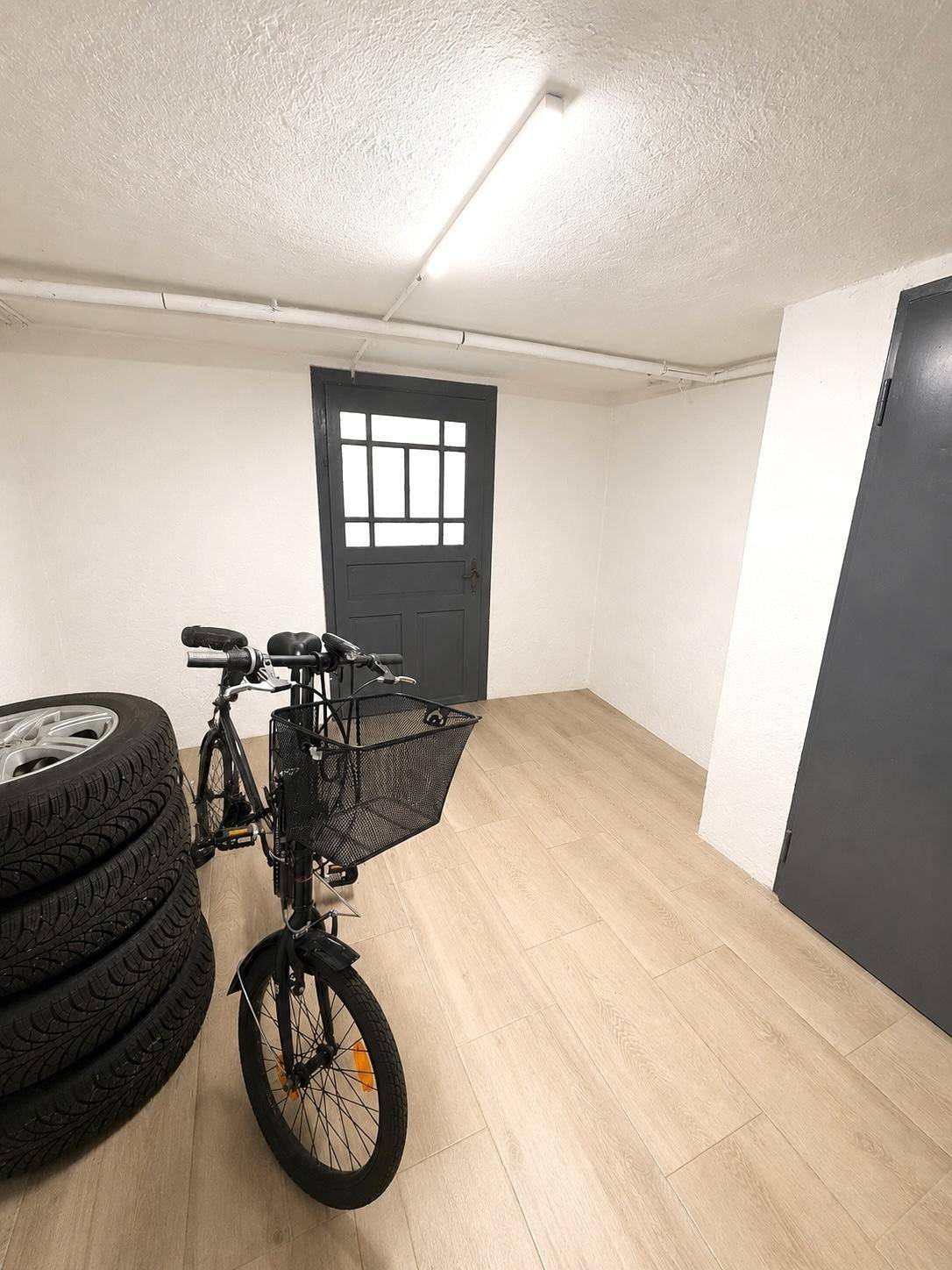 Abstellraum mit Fahrrad, Reifen und praktischem Laminatboden.