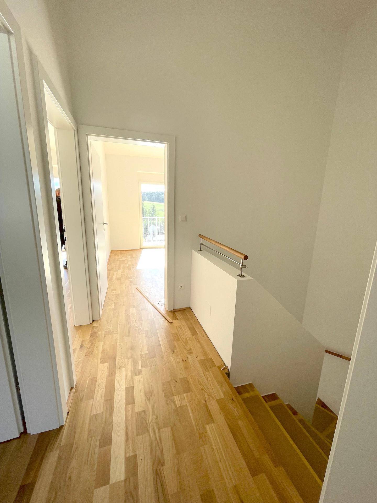 Heller Flur mit Holzfußboden und Treppe, die zu den oberen Zimmern führt.