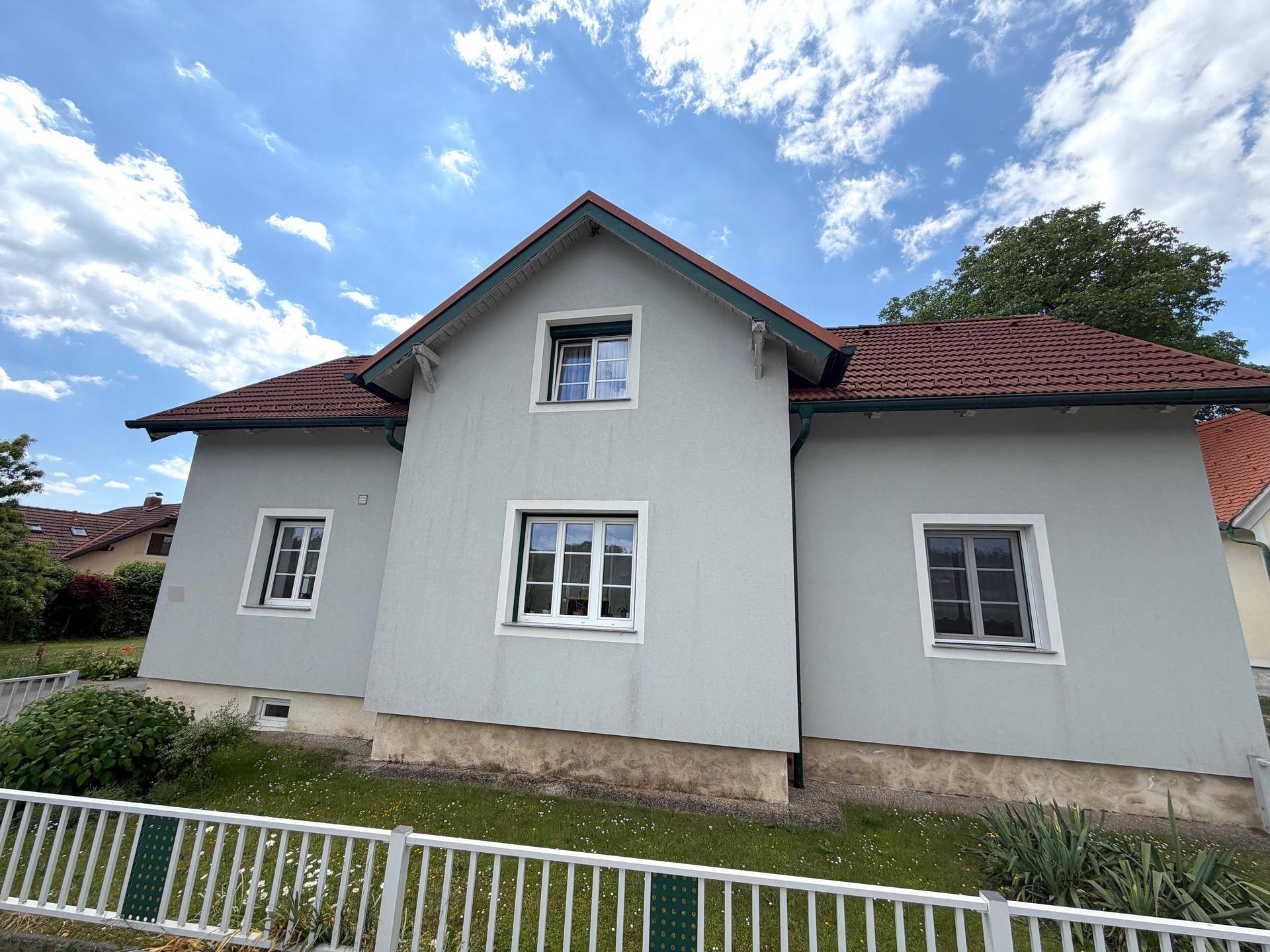 Vorderansicht des Wohnhauses mit gepflegter Fassade, mehreren Fenstern und traditionellem Ziegeldach.