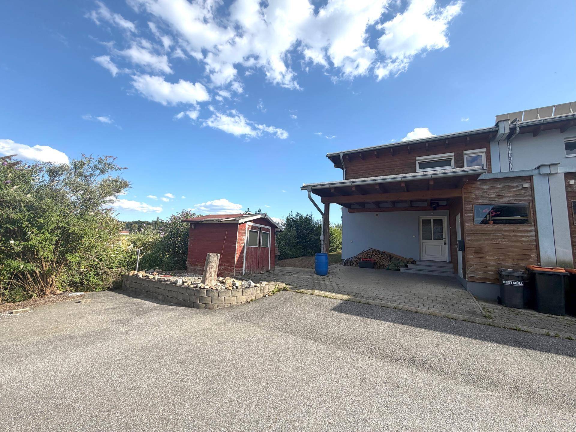 Zufahrt zum Haus mit Carport, Gartenhaus und weitem Blick in die Landschaft.