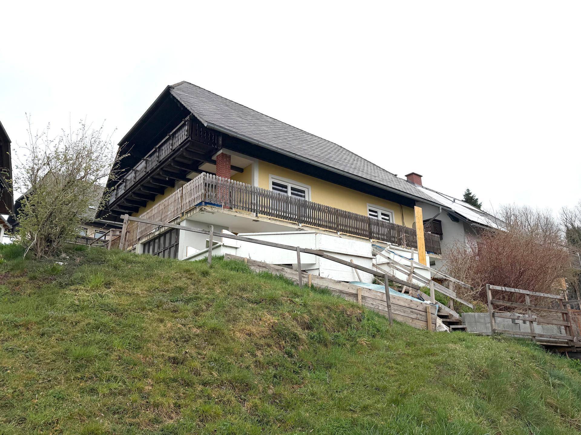 Traditionelles Haus in Hanglage mit mehreren Balkonen und Blick auf die Natur.