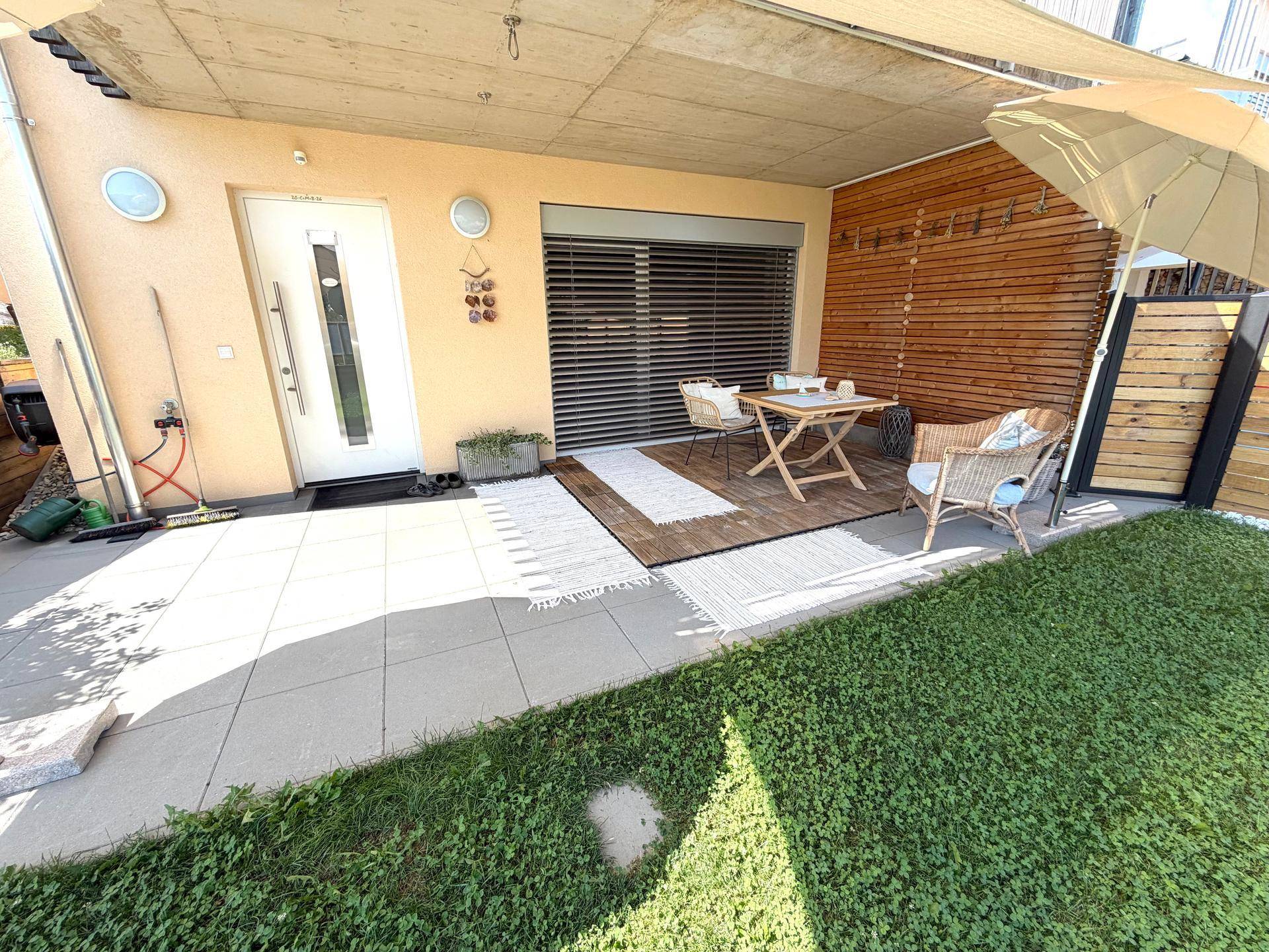 Einladende Terrasse mit Sitzgelegenheiten, Sonnenschutz und direktem Zugang zum Haus.
