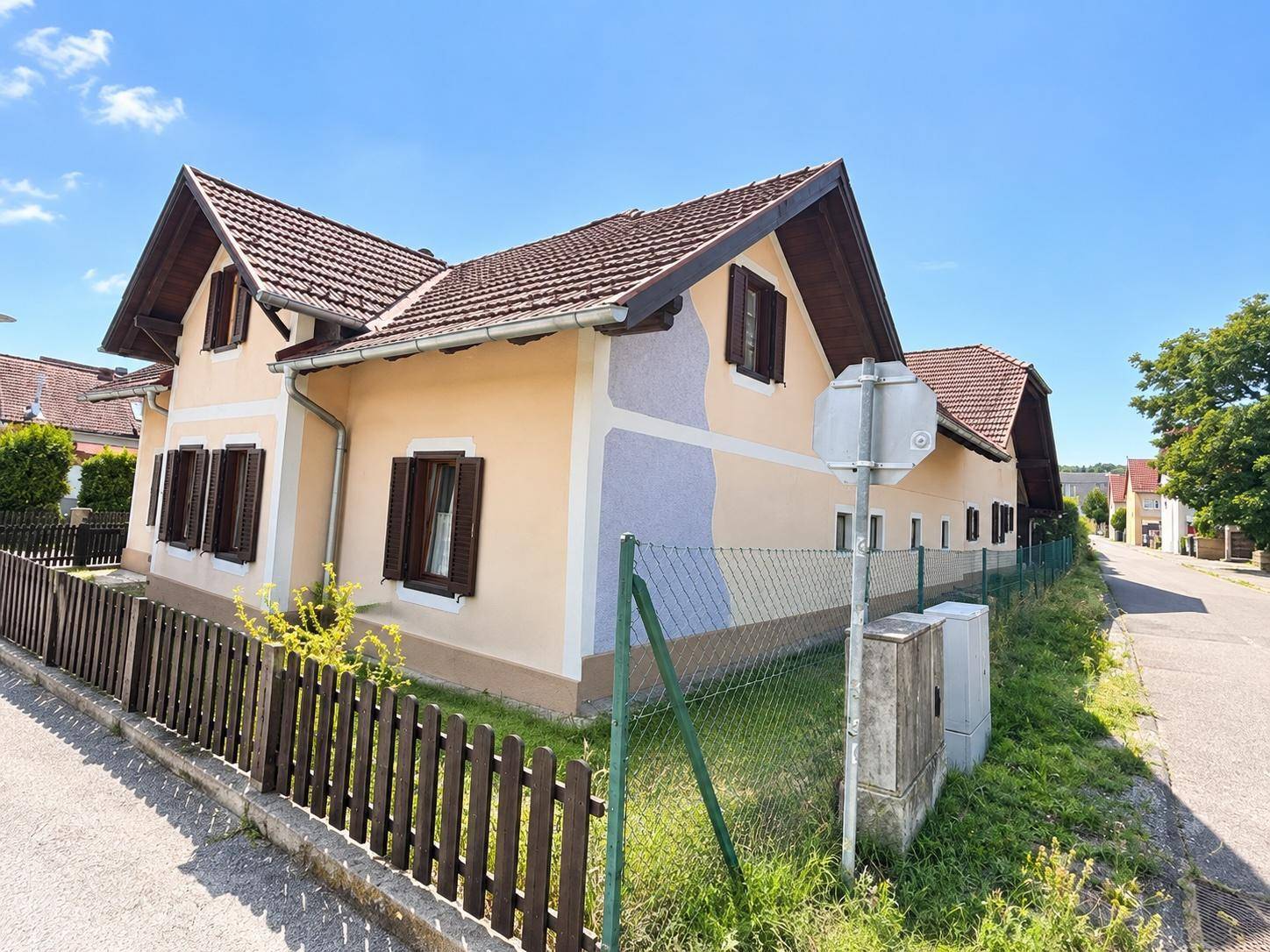 Charmantes Einfamilienhaus mit Satteldach, Fensterläden und einem gepflegten Vorgarten.