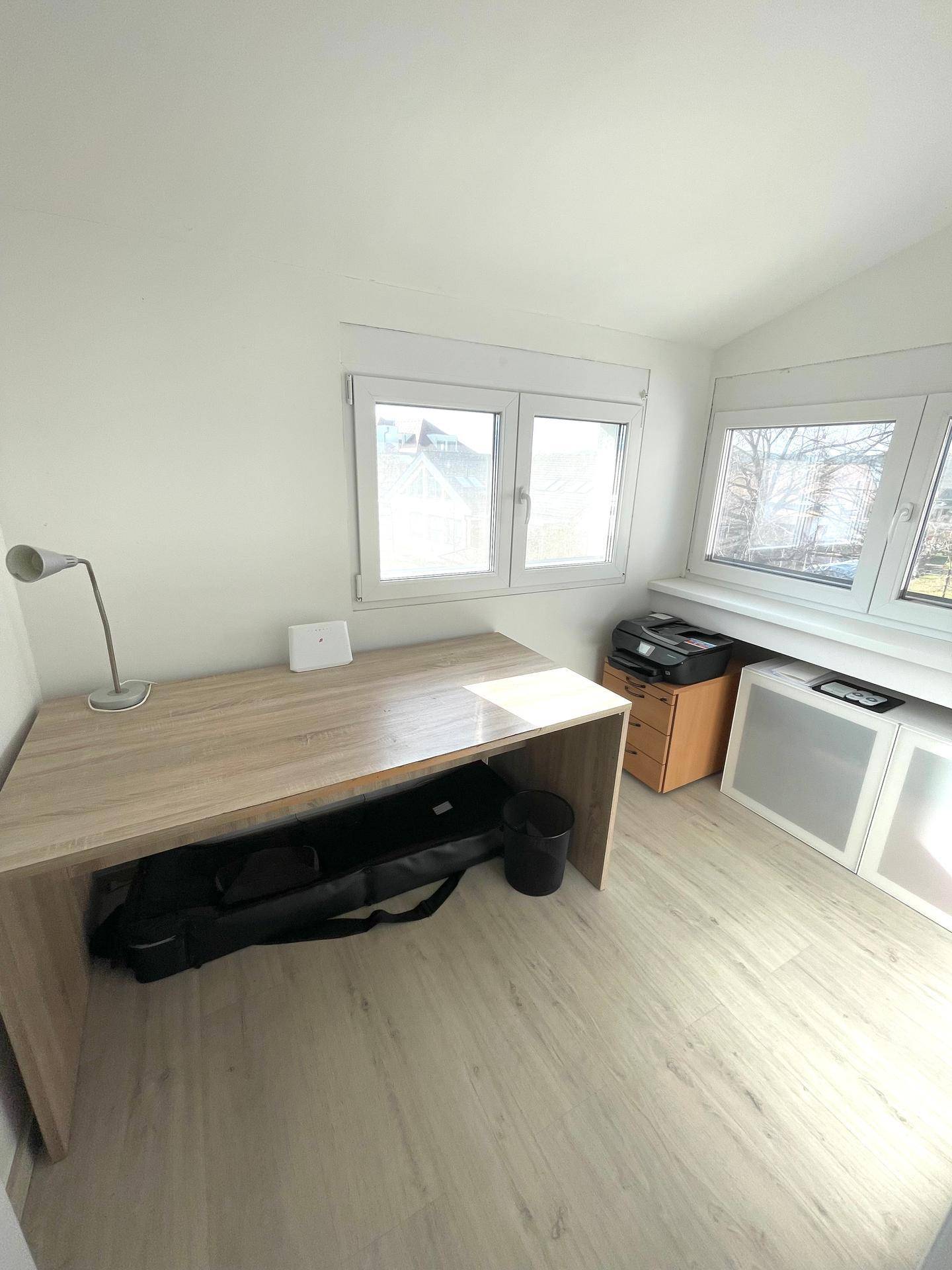 Helles Arbeitszimmer mit Schreibtisch und Fenstern, bietet viel Tageslicht.