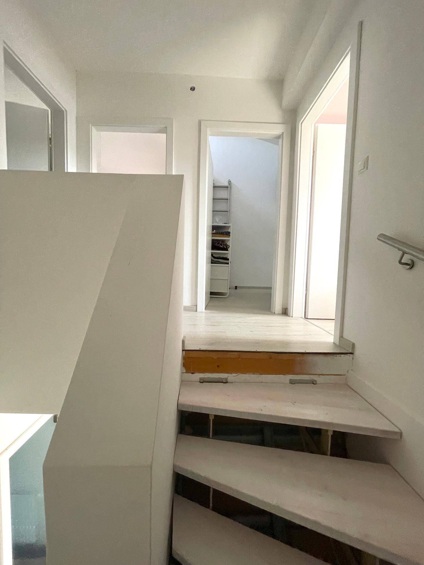 Heller Flur im Obergeschoss mit Zugang zu mehreren Zimmern und Treppe.