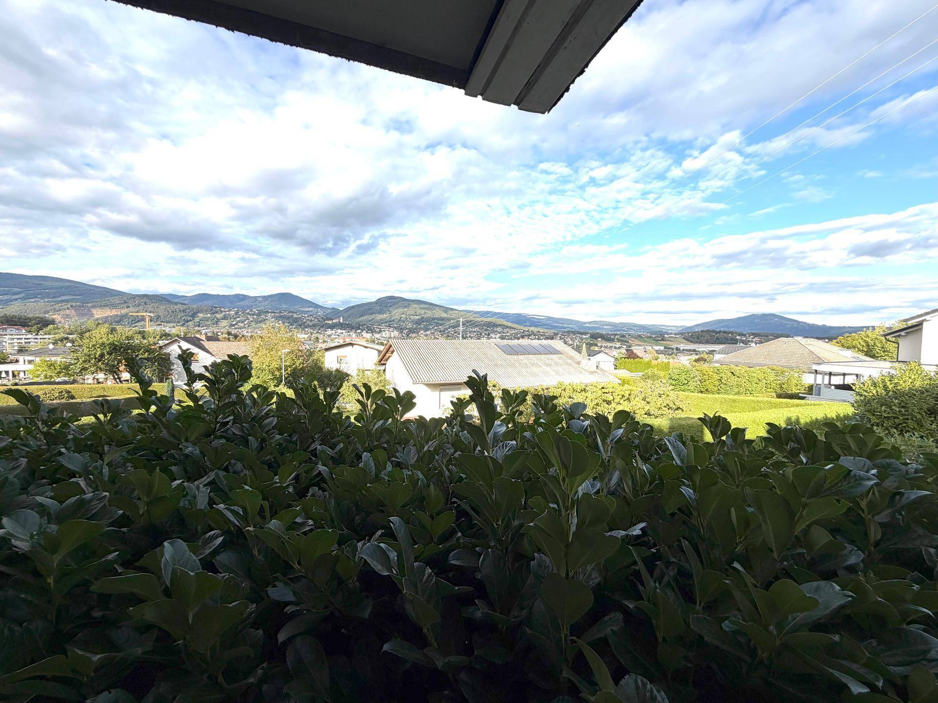 Weitblick über die Wohnsiedlung und die umliegende Berglandschaft von einem erhöhten Punkt.