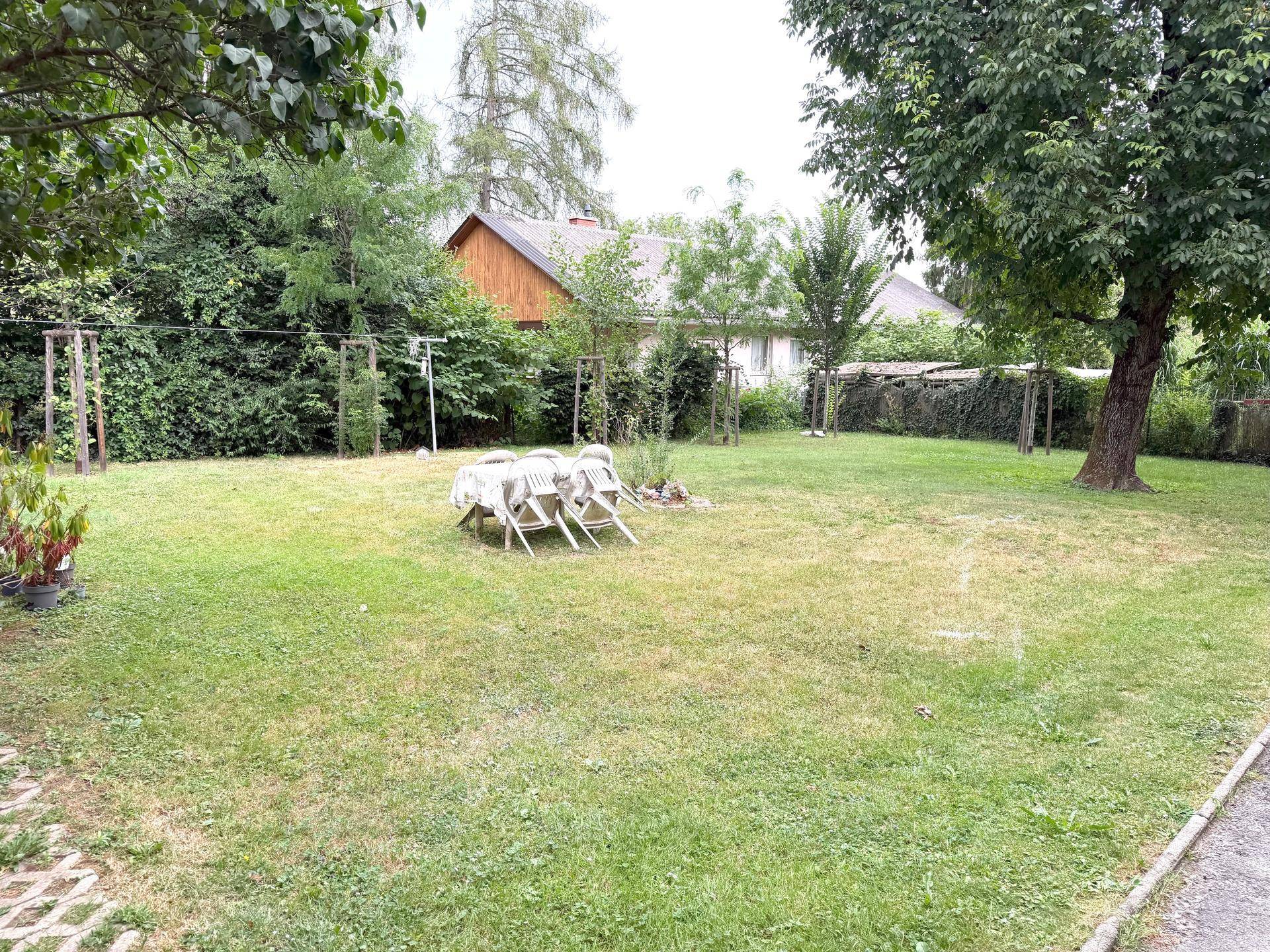 Großer, gepflegter Garten mit Rasenfläche und Sitzgelegenheiten im Freien.