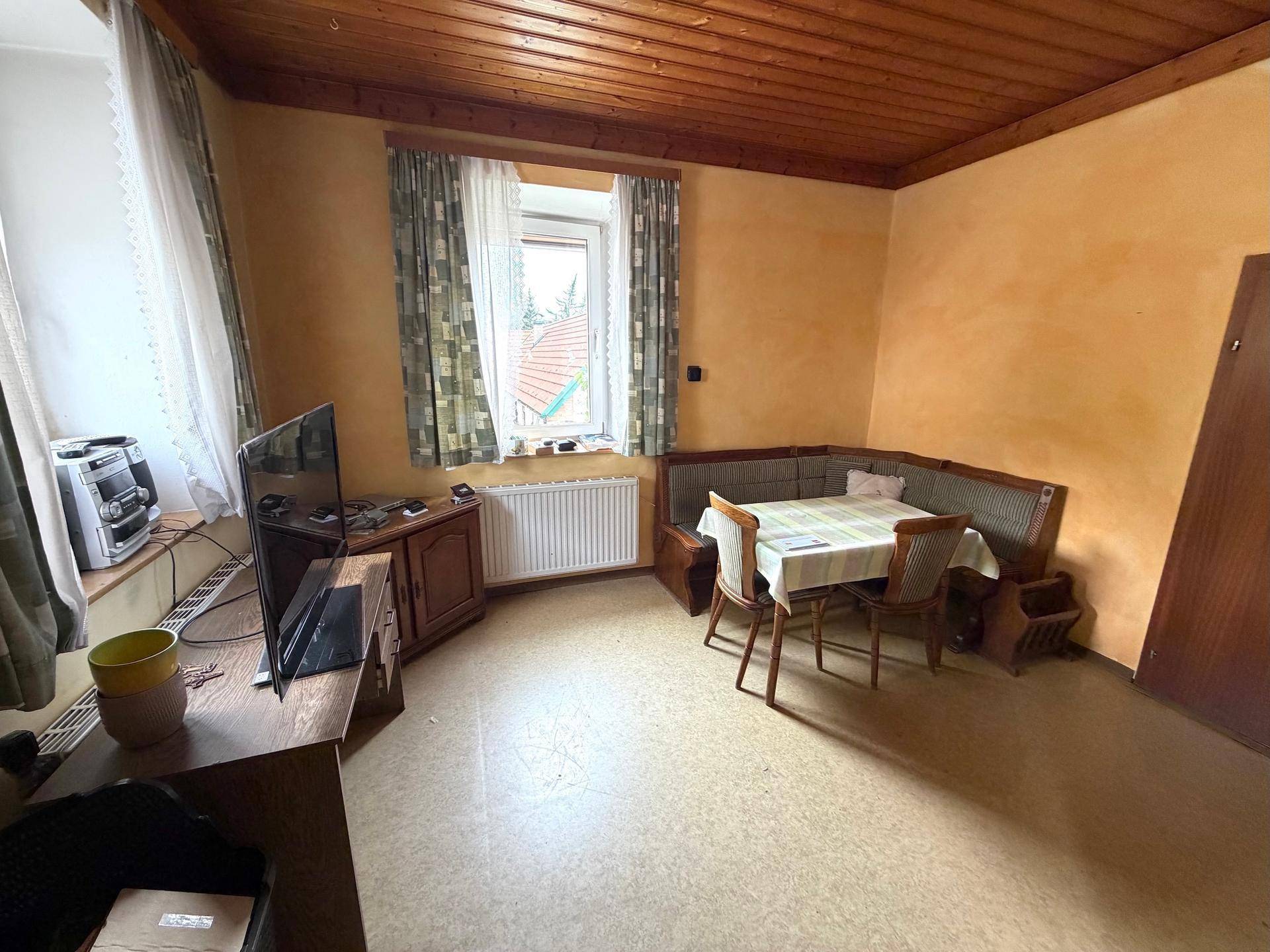 Gemütlicher Essbereich mit Eckbank, Holztisch und Blick ins Grüne.