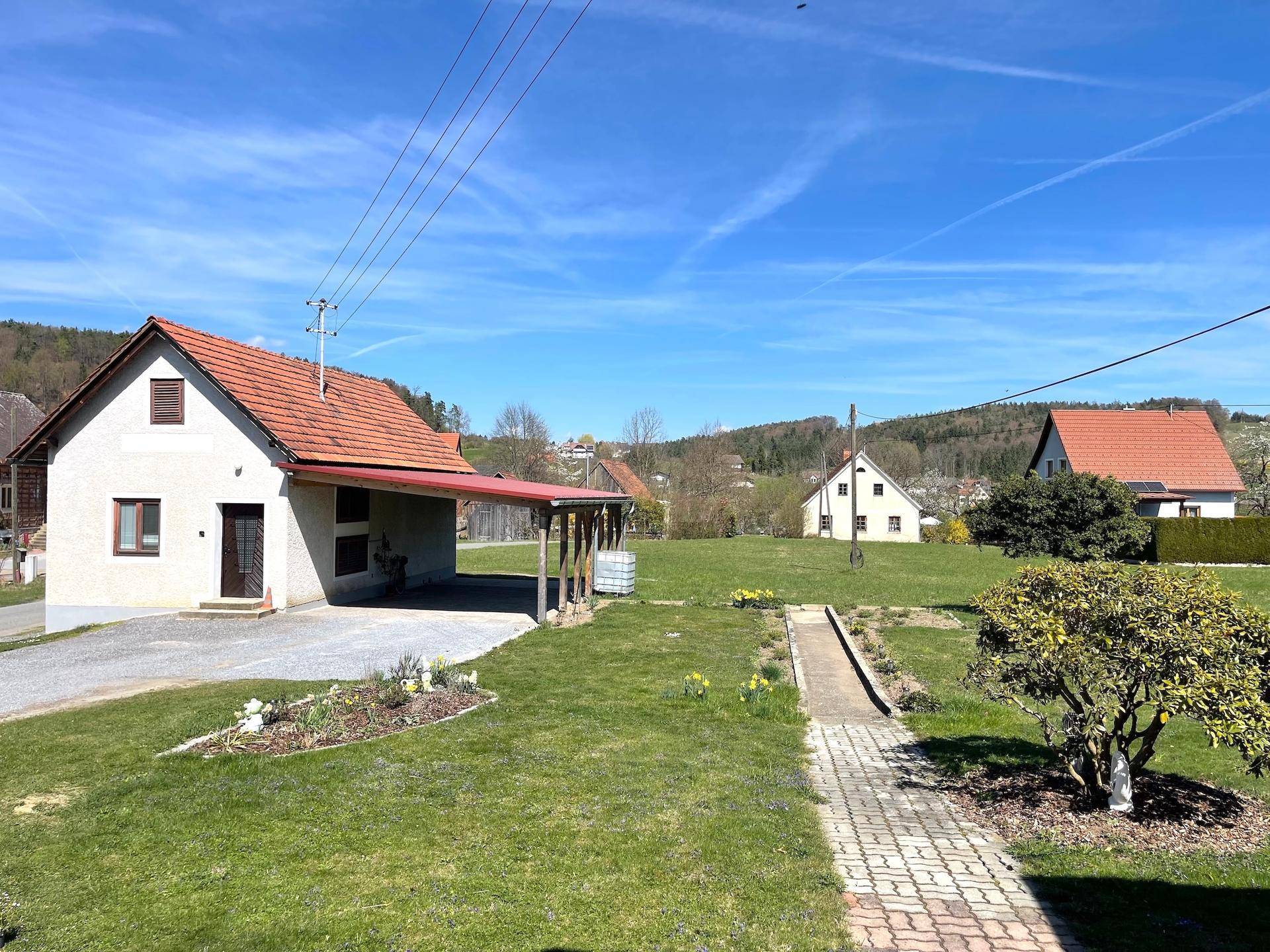 Großzügiger Gartenbereich mit Rasenfläche, Wegen und ländlichem Ausblick.